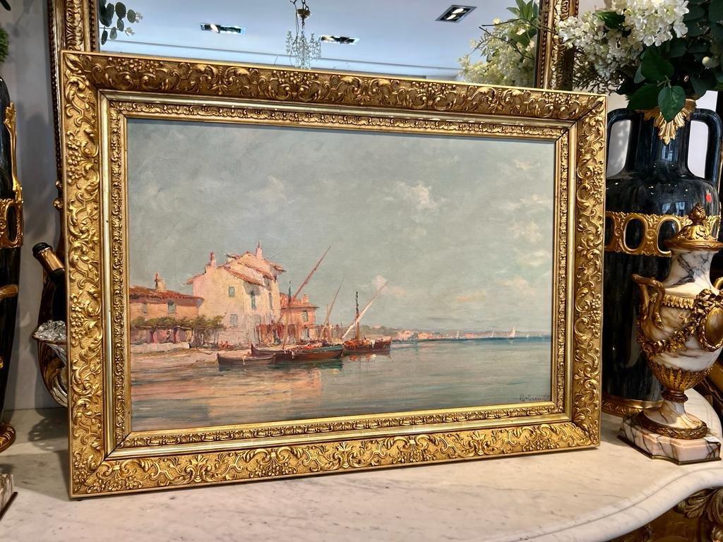 Nous vous présentons cette vibrante huile sur toile représentant le port de Martigues, réalisée par le célèbre artiste Charles Malfroy, né à Lyon en 1862 et décédé au Kremlin-Bicêtre en 1939. Sa signature est visible dans le coin inférieur droit.