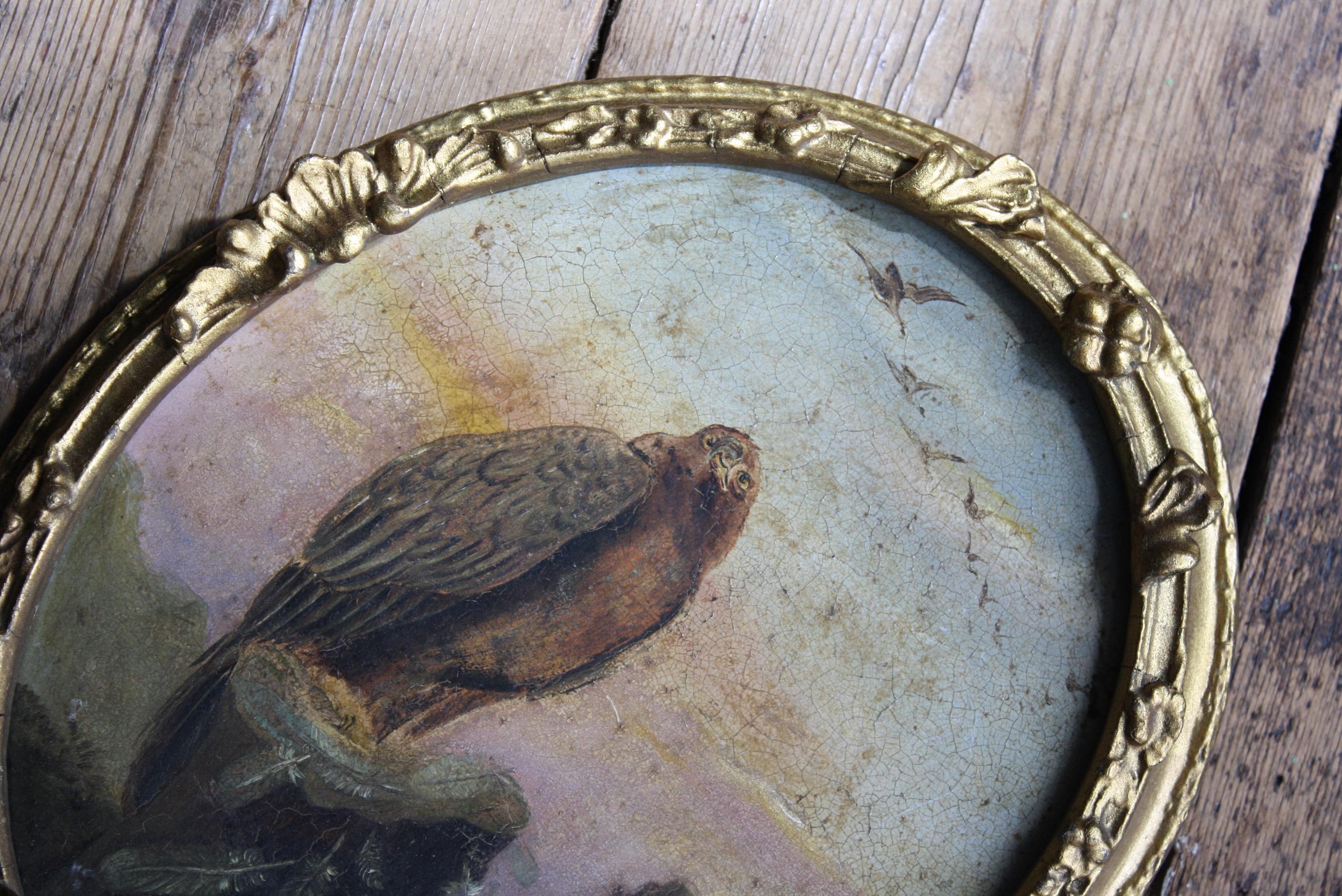 A charming and well executed oil on tin depiction of a golden eagle perched on a rock face with a pleasing pallet of pink and yellow.

19th century in age, housed in it original oval frame with some later over painted gilt work. Age related