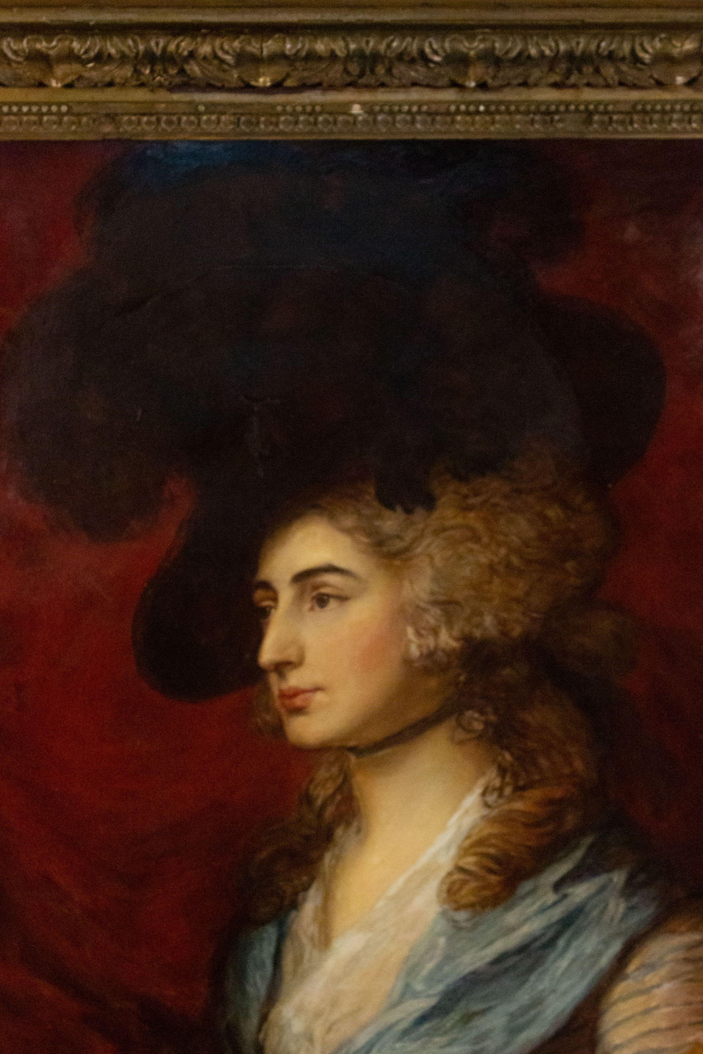 19th century gilt framed oil painting portrait of lady wearing black hat and blue striped dress.
 