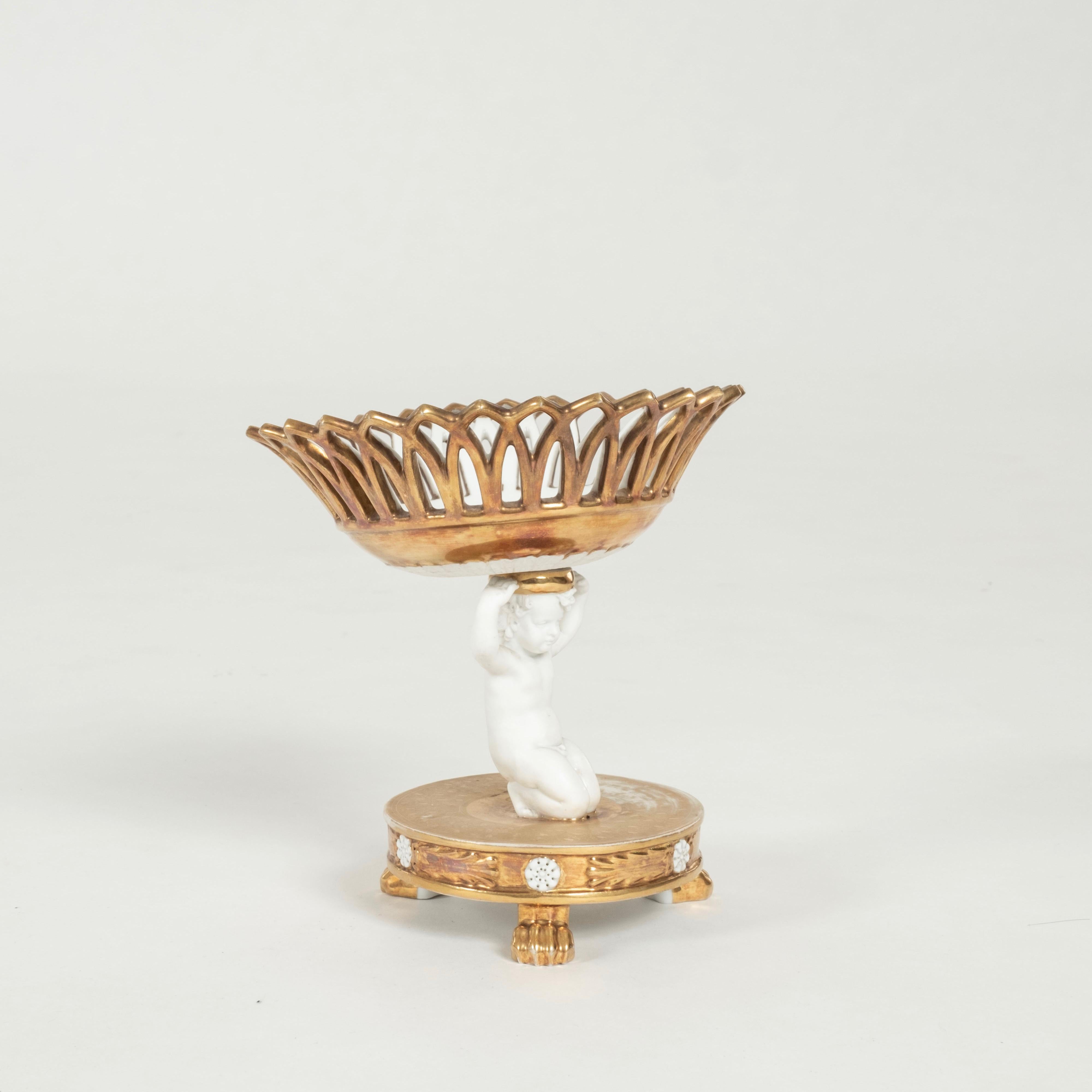 Porcellana Old Paris del XIX secolo: una composta reticolata e smaltata in oro con un cherubino inginocchiato.
