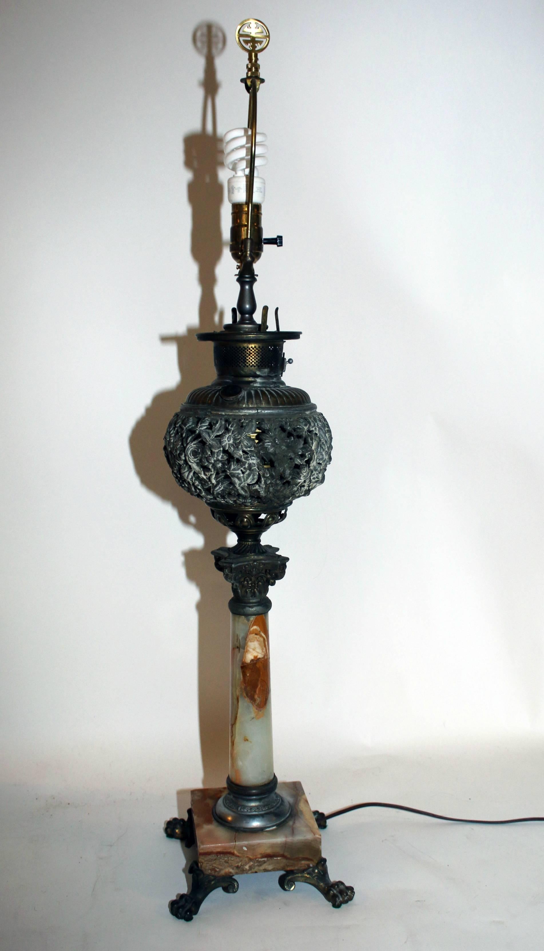 Antique oil burning lamp converted to electricity. Features include reticulated bronze ormolu in a floral pattern with an onyx marble Corinthian column and base. Beautiful veining in the marble.
Bronze paw feet. Silk shade.
The measurement below are