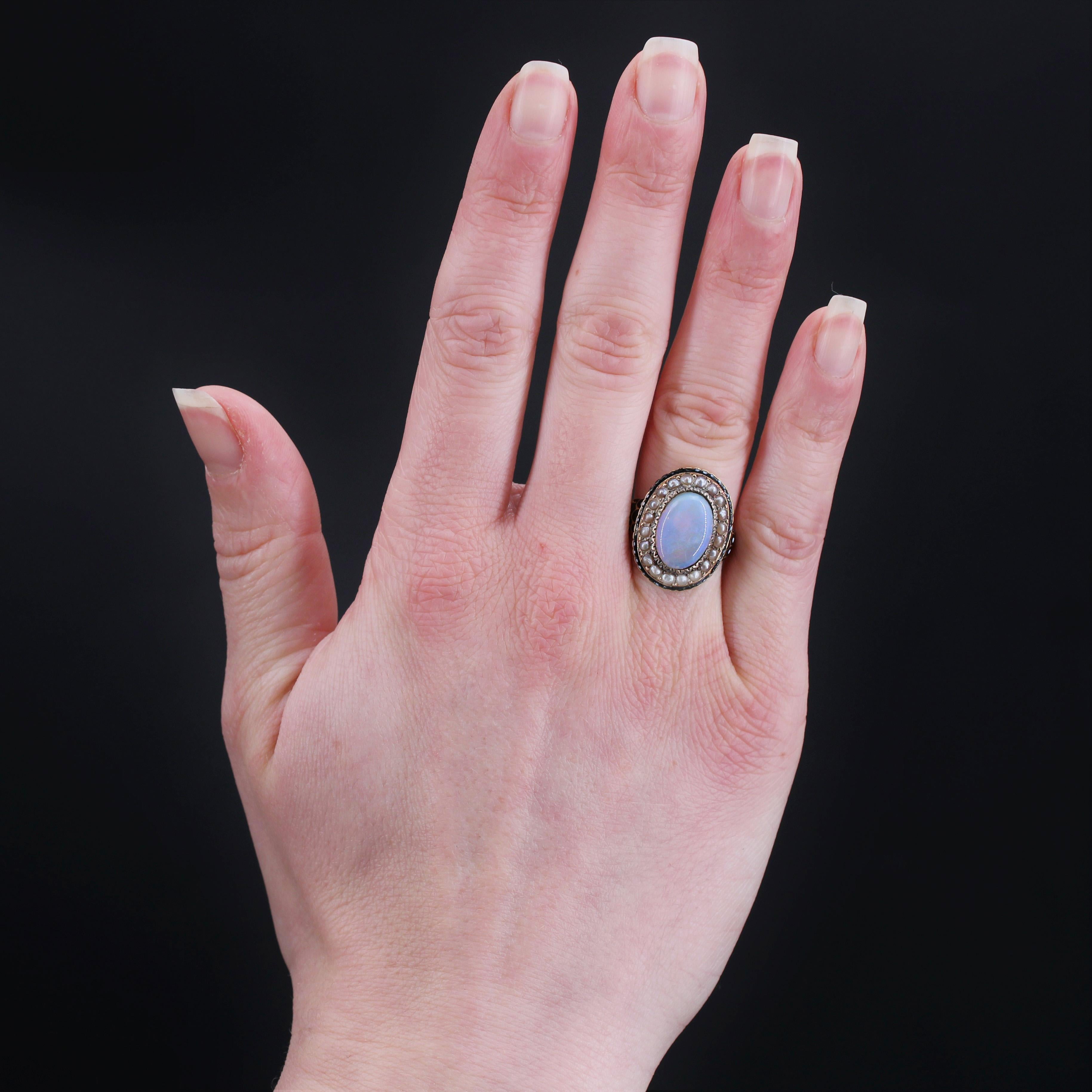 Bague en or jaune 18 carats, poinçon propre.
Belle et rare bague ancienne, elle est ornée d'un cabochon en opale au centre d'un décor ciselé, entouré de demi-perles fines et d'une bordure d'émail noir et blanc. Le début de l'anneau est large, formé