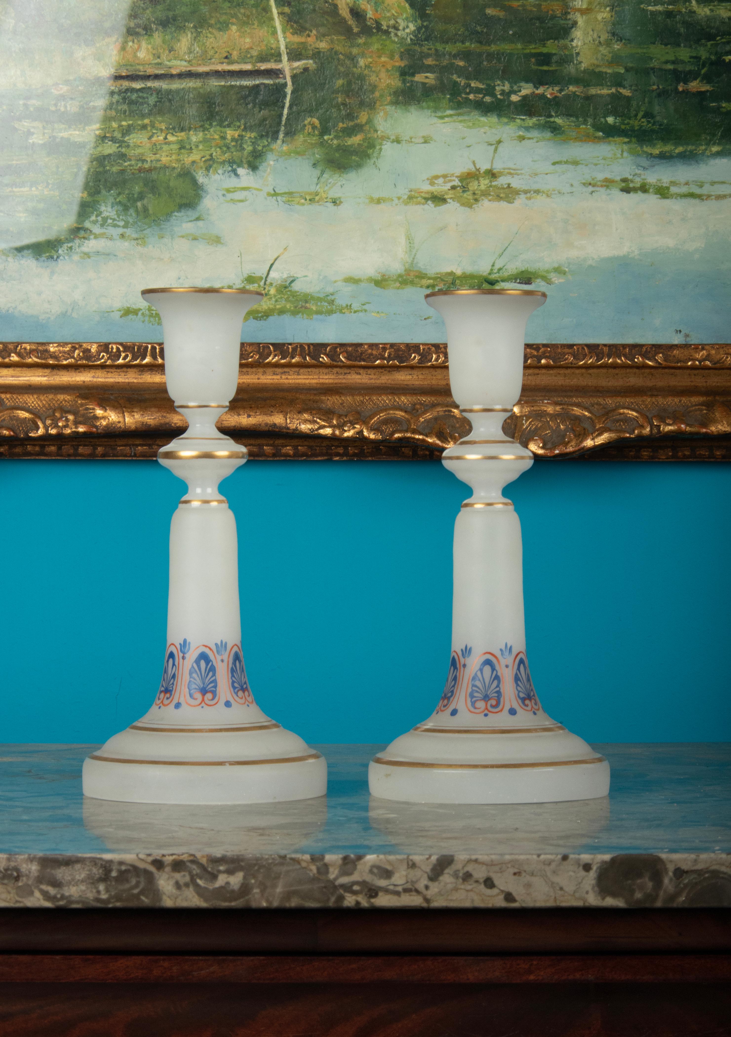 A beautiful pair of candlesticks, made of satined, matted opaline glass. Hand painted with gold colored edges and gothic motifs. The candlesticks are in good condition, the decorations are still nicely intact.