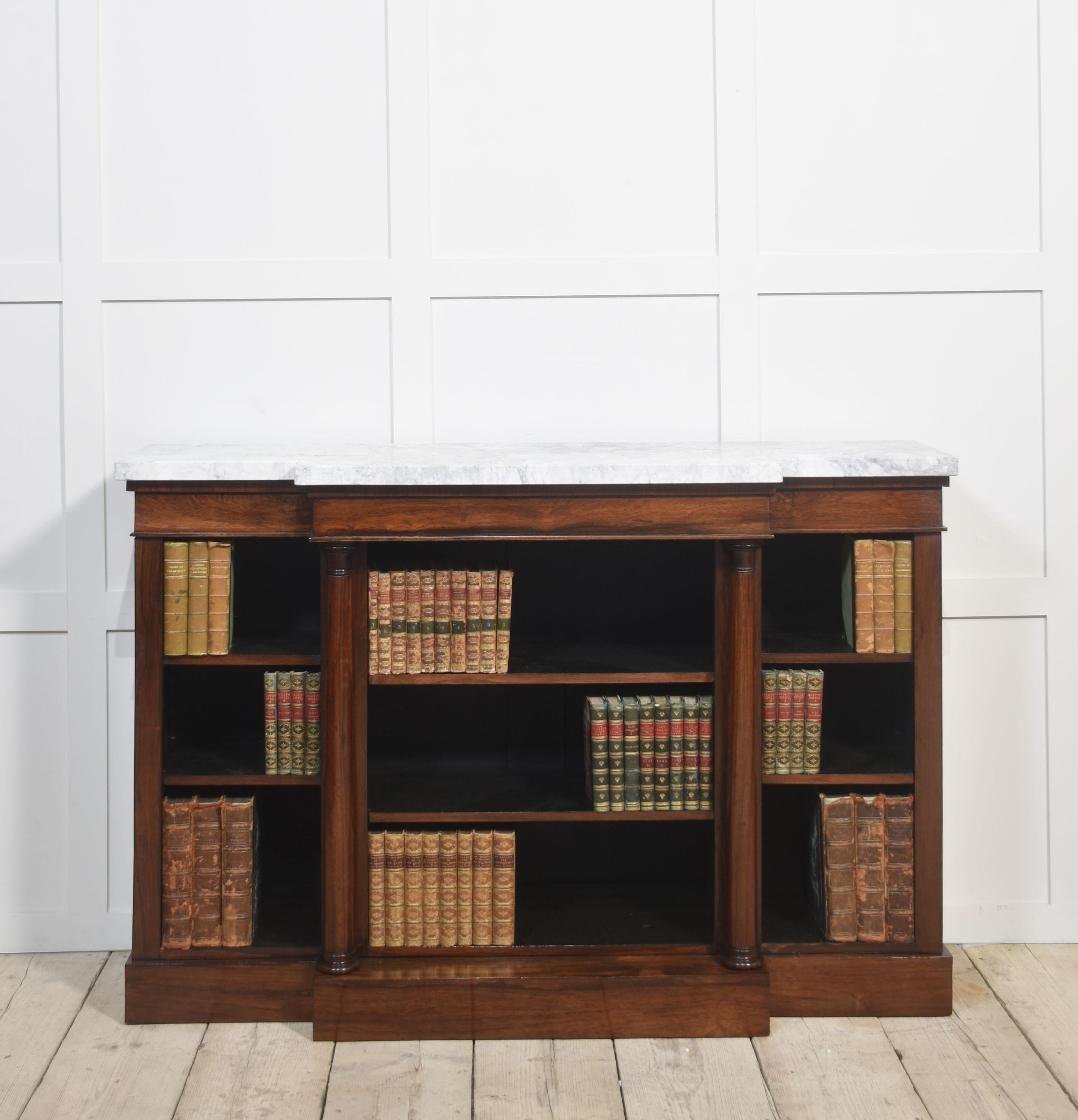 Libreria a giorno, il grande piano rettangolare ben figurato con fronte a rompicollo in marmo sovrasta tre campate di ripiani regolabili, divisi da pilastri circolari. Il tutto sollevato su una base a plinto.
Dimensioni
Altezza 37 pollici
Larghezza