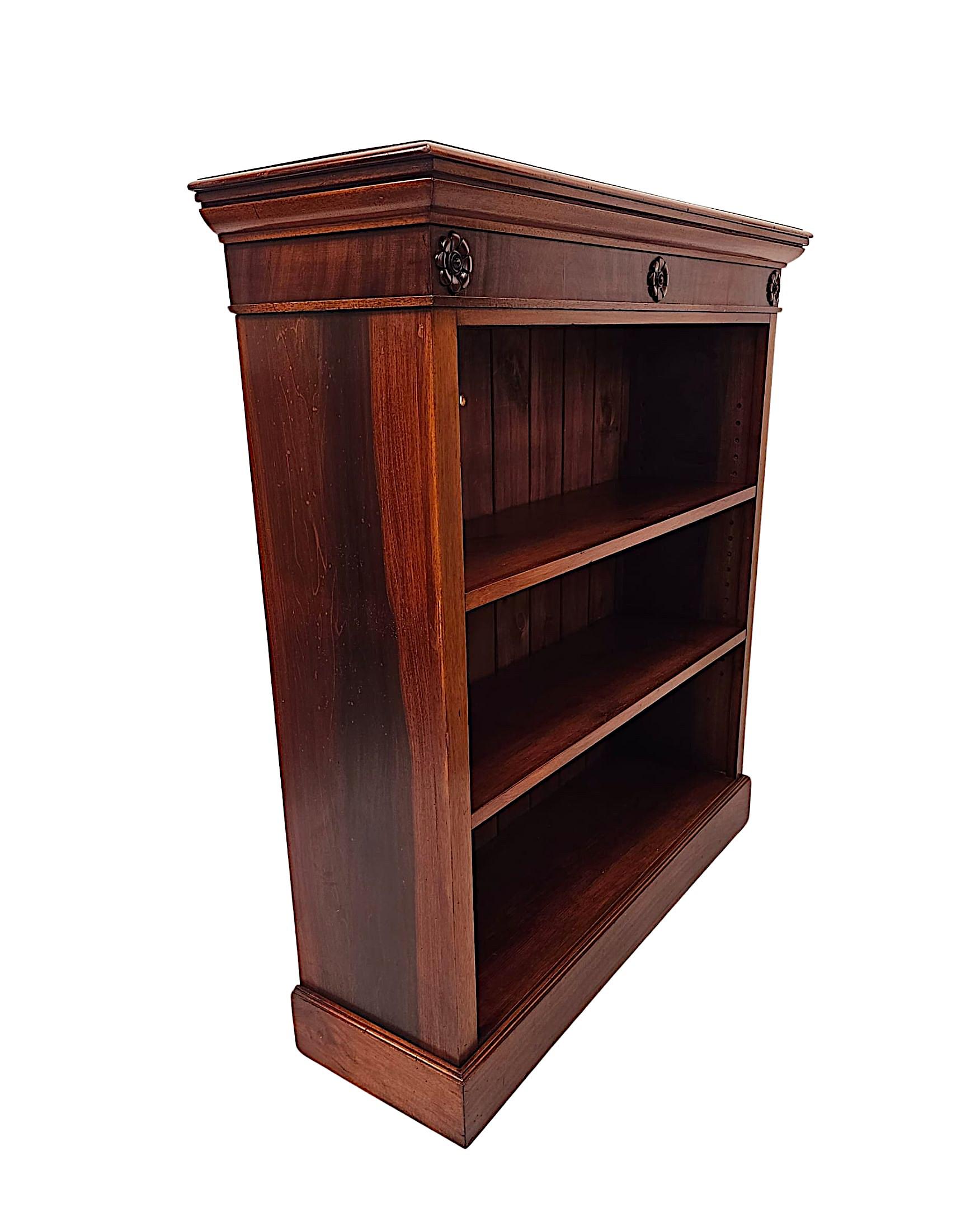 Una favolosa libreria a giorno in mogano del XIX secolo, finemente intagliata a mano e di qualità eccezionale con una patina e una venatura meravigliosamente ricche.  Il piano a cavetto di forma rettangolare, ben modellato e a gradini, si eleva su