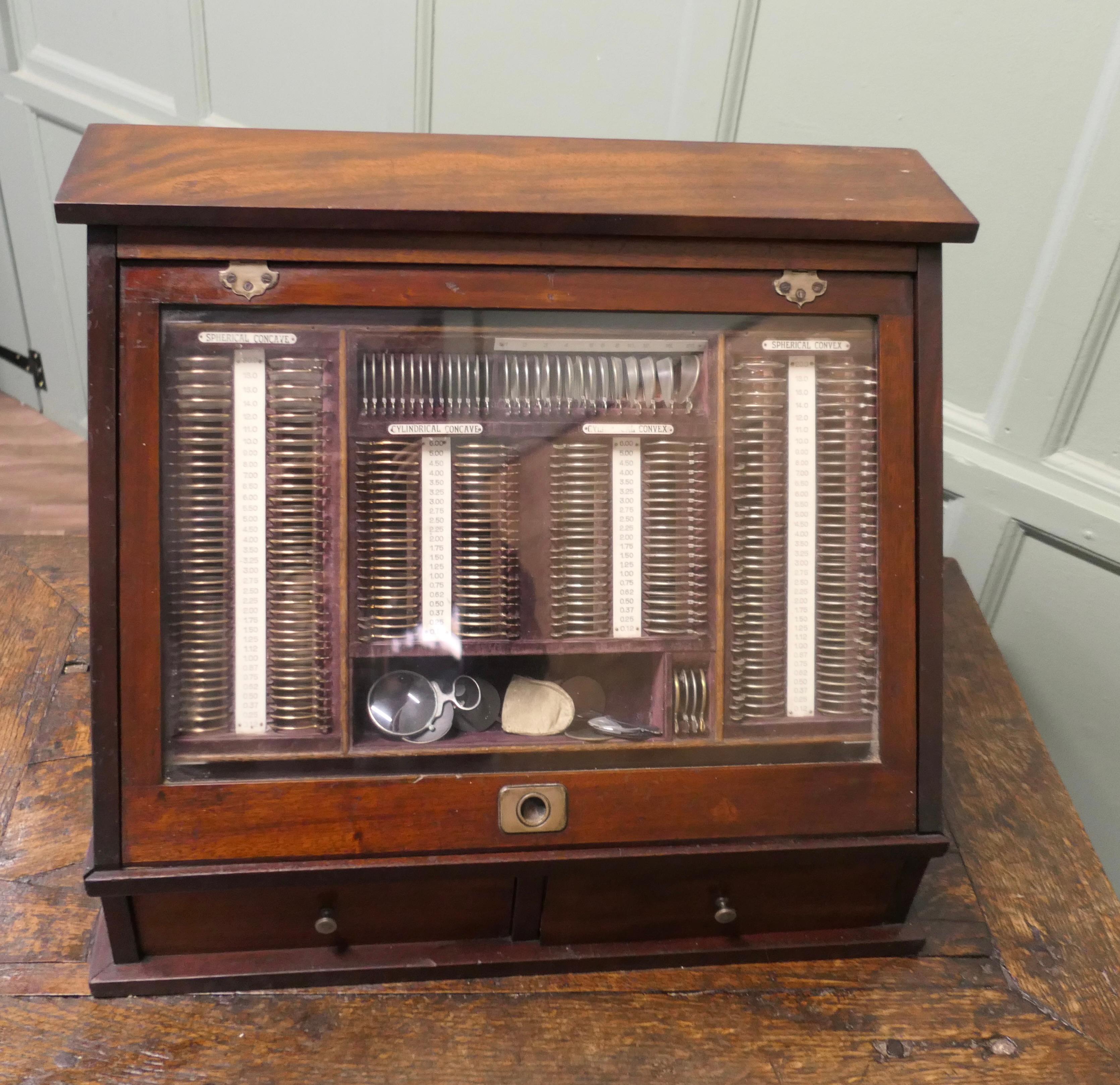 19th Century Optician or Optometrist Test Glasses Lens Kit in Cabinet 

This beautiful cabinet was used by a traveling optometrists to treat patients in their homes.  
The glass front lifts up and slides down inside the cabinet on a tambour  to