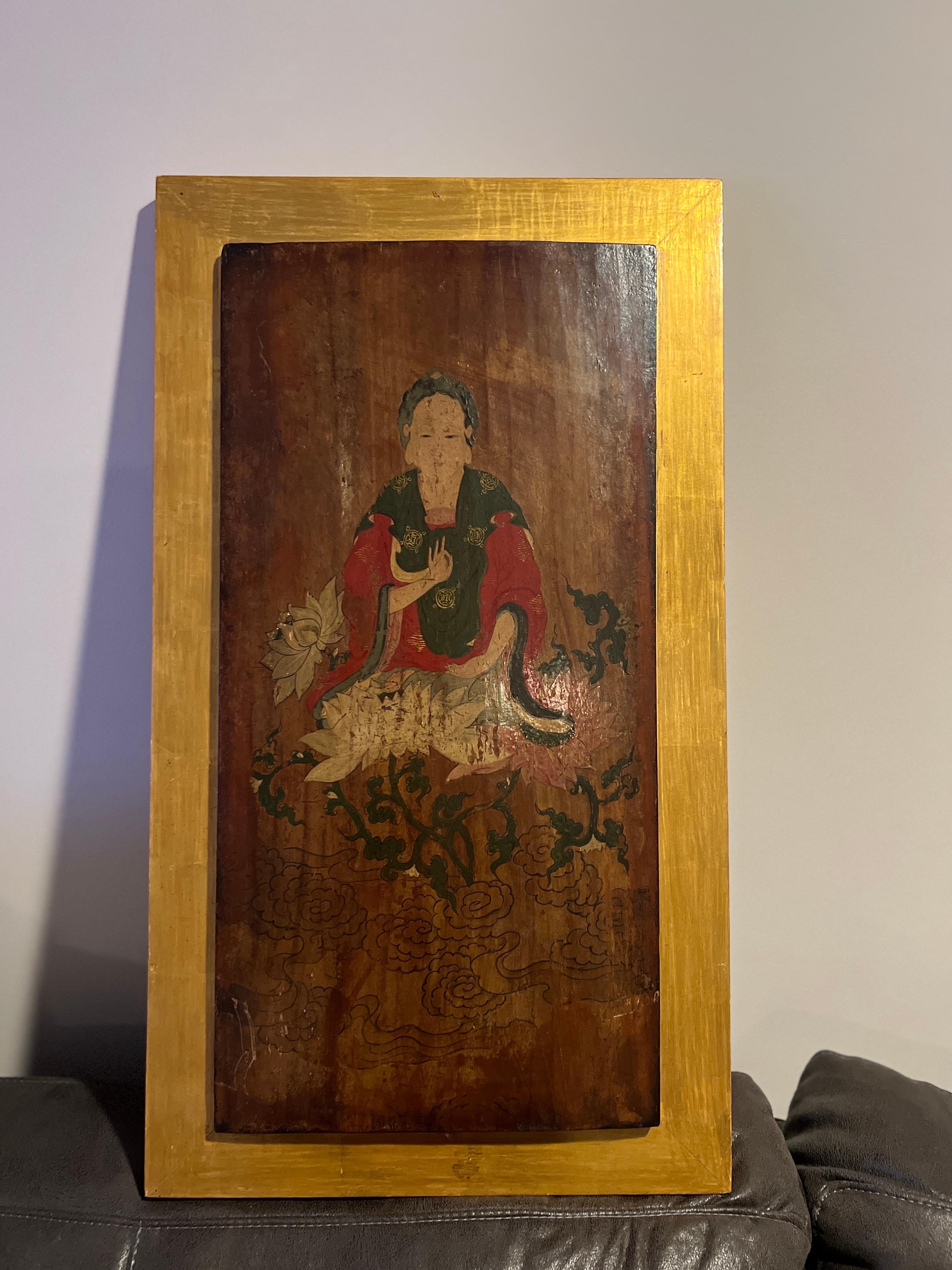 Possibly Chinese or Tibetan, I believe this piece is 18th century but it might even be earlier. 
A beautiful quality antique painted wood panel depicting Buddhist god Guanyin. The antique panel is set inside a 20th century gilt wood accent 
