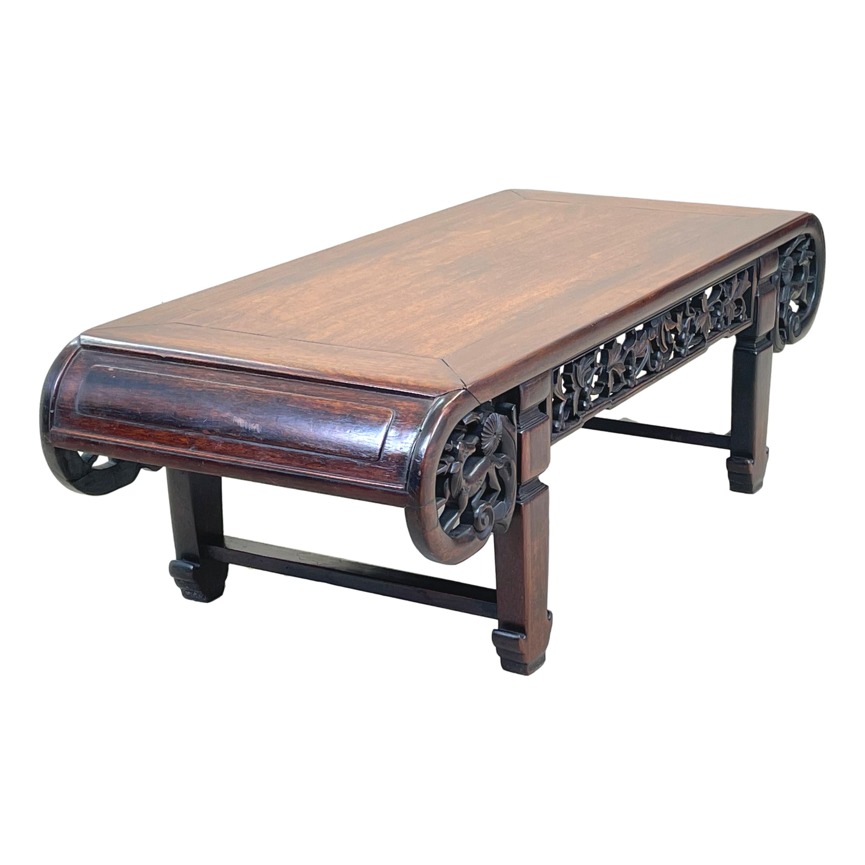 An attractive and very good quality mid 19th century
oriental hardwood coffee table, of unusual design
similar to an opium type table, having well figured
panelled top with elegant scrolling ends and pierced
carved fretwork decoration to frieze