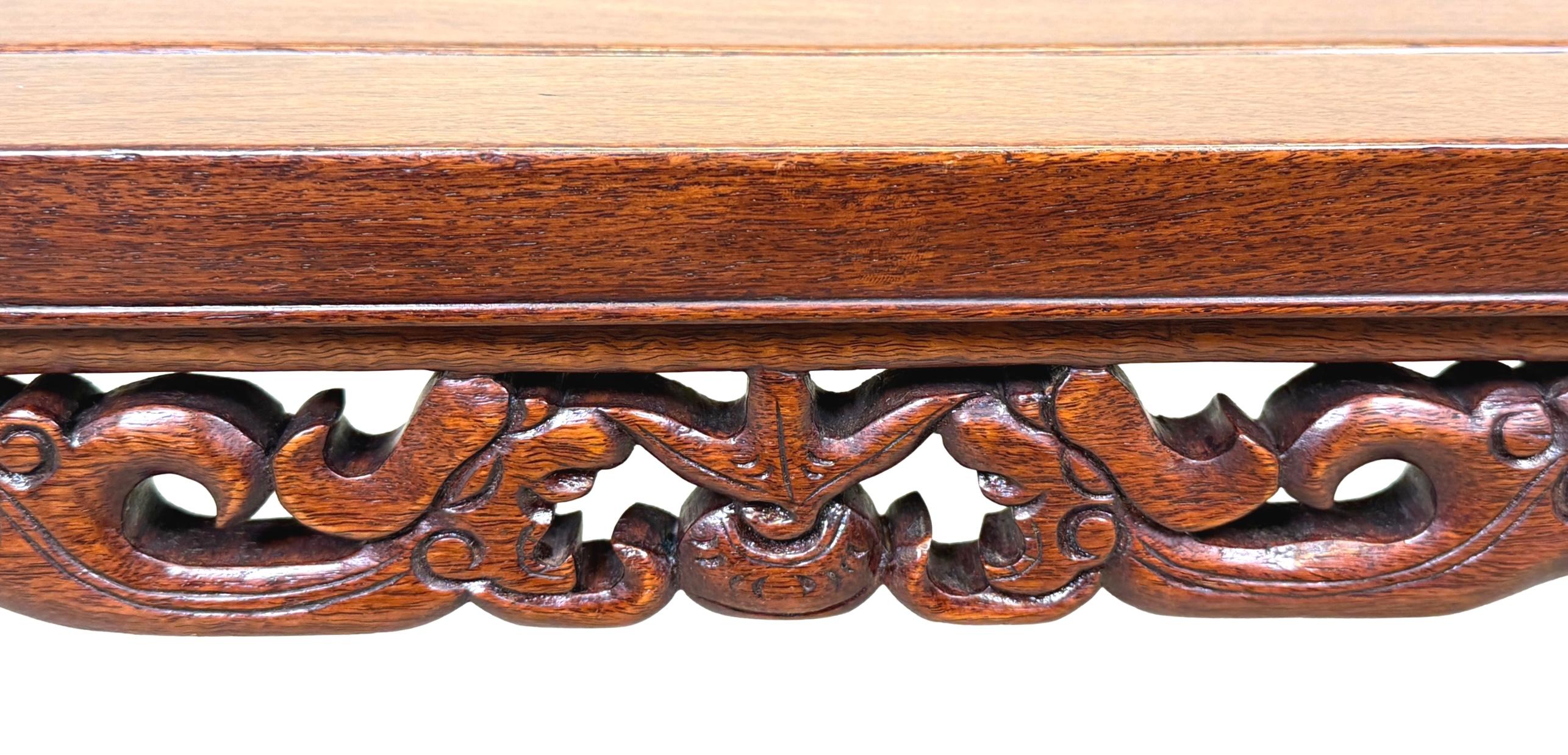 Table à café ou table à opium en bois dur oriental de très bonne qualité, datant de la fin du XIXe siècle, dont le plateau rectangulaire à panneaux bien figurés est surmonté d'une frise percée joliment sculptée, flanquée de supports d'extrémité