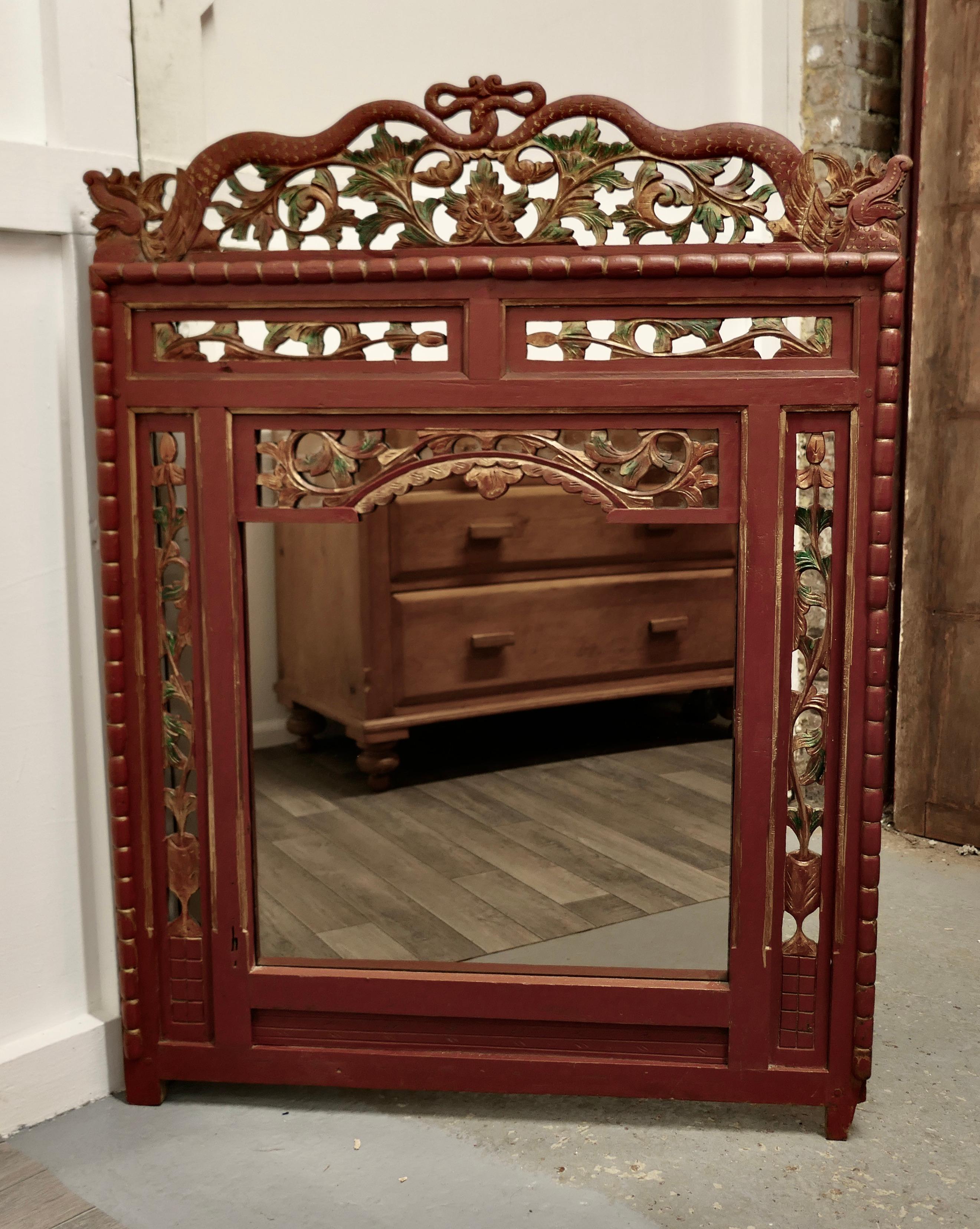 19th Century Oriental Painted Red Lacquer Mirror

This is a very attractive 19th Century Painted mirror Frame, it is painted mainly in Red Lacquer with carved and painted decoration
The top of the mirror has dragons with entwined tails and detailed
