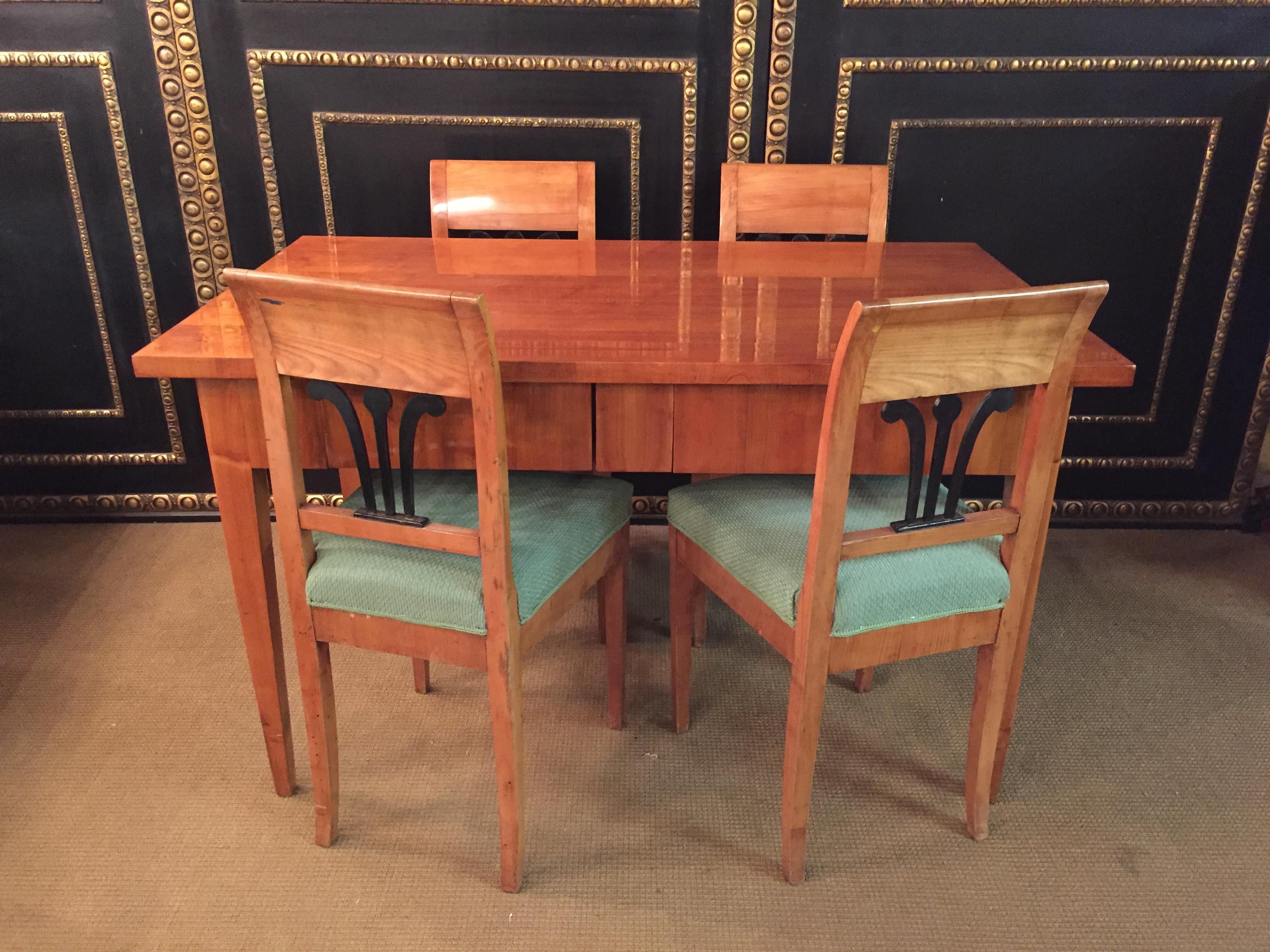 Original Biedermeier dining table with 4 chairs 19th century. 
It is made of cherrywood. With shellac hand polish.
The table legs are solid cherrywood. A wonderful timeless design, dates back to the time of Biedermeier, circa 1820. The drawer is,