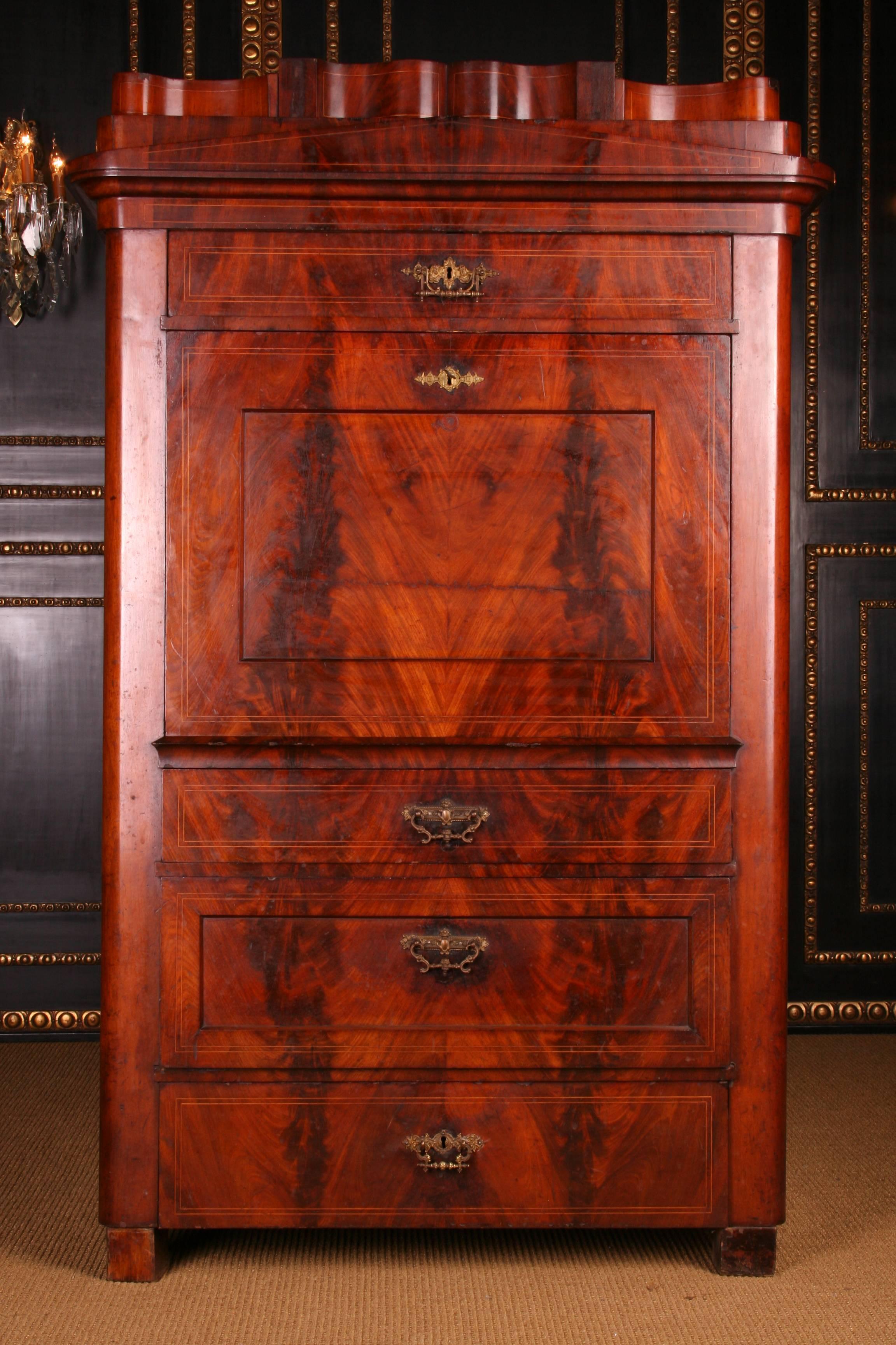 Cuba mahogany on solid conifer, high-rectangular body on log feet. In the articulated front four drawers of different sizes with partial recessed fillings. Cramped cornice, with final chink roof and stepped pedestal with hidden drawer. 

Excellent