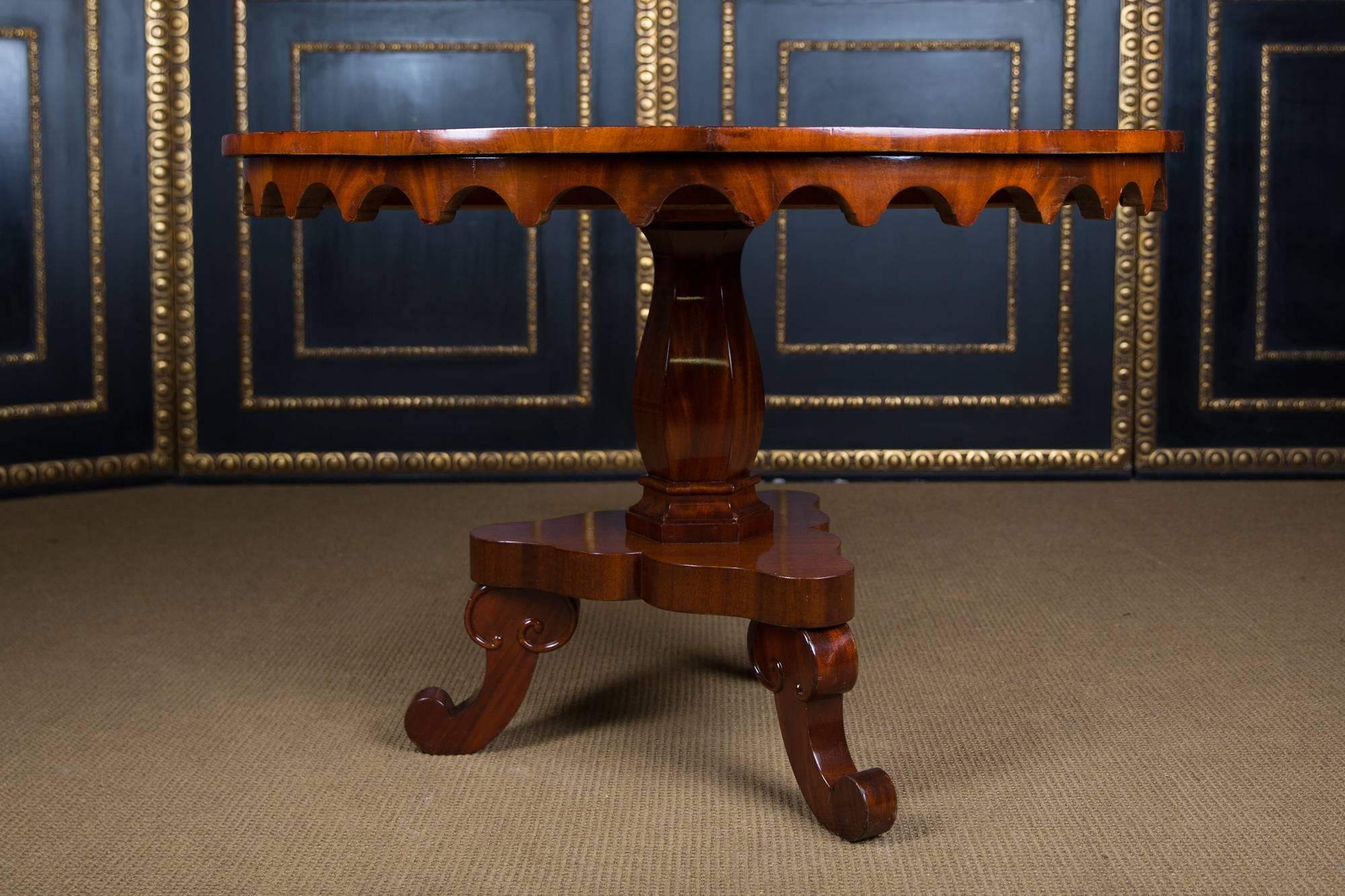 Mahogany wood, slender, multi-articulated columns, below are three volute-shaped legs. Gothic frame, with protruding profile plate.

The tabletop can be folded forward.

Good condition.

A good historical condition with a beautiful warm patina.

