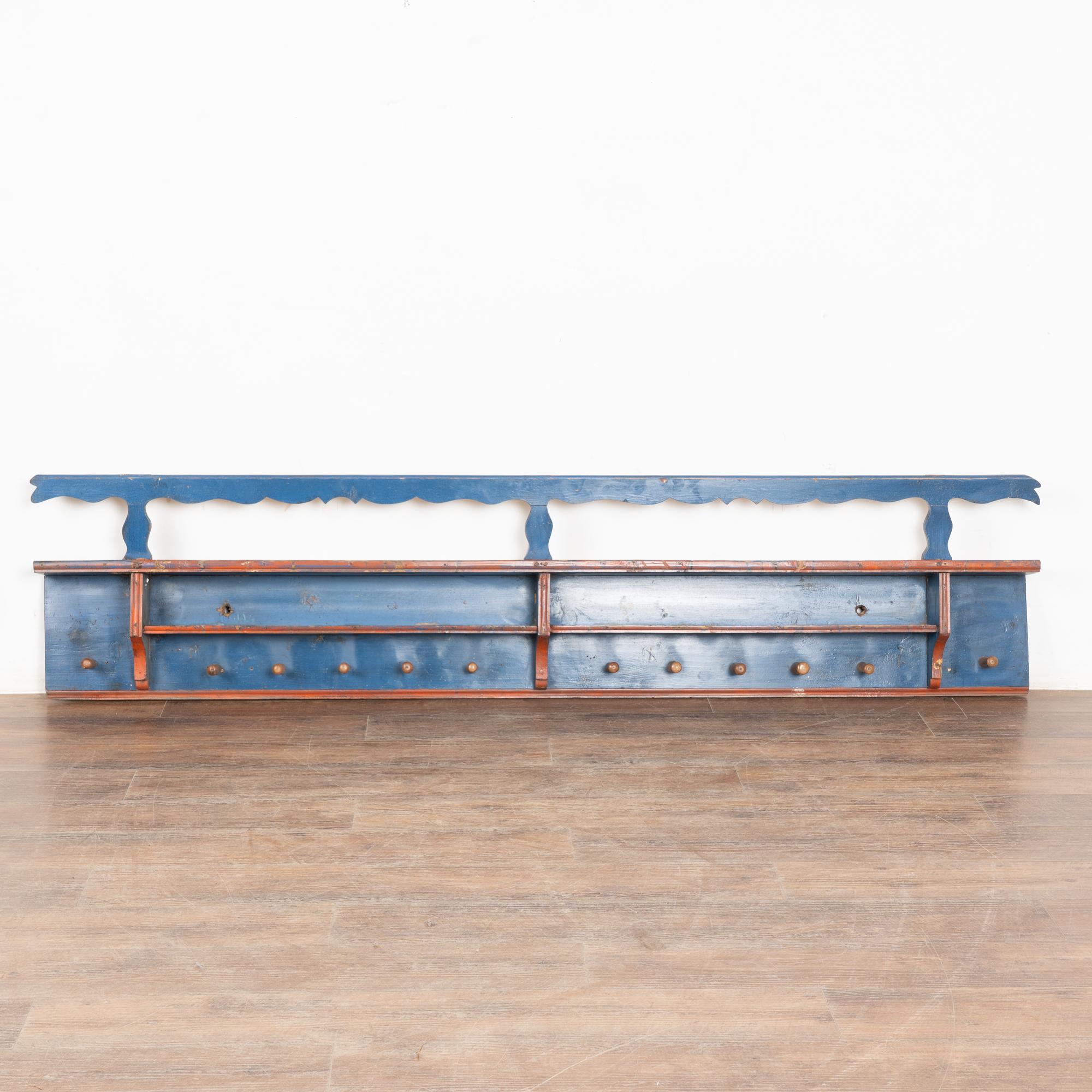 Questo appendiabiti festoso è un meraviglioso esempio dell'arte popolare che si trovava nell'Europa dell'Est durante il 1800.
Lo sfondo originale dipinto di blu ha un tradizionale bordo rosso a contrasto.
Su questa rastrelliera lunga 7' ci sono