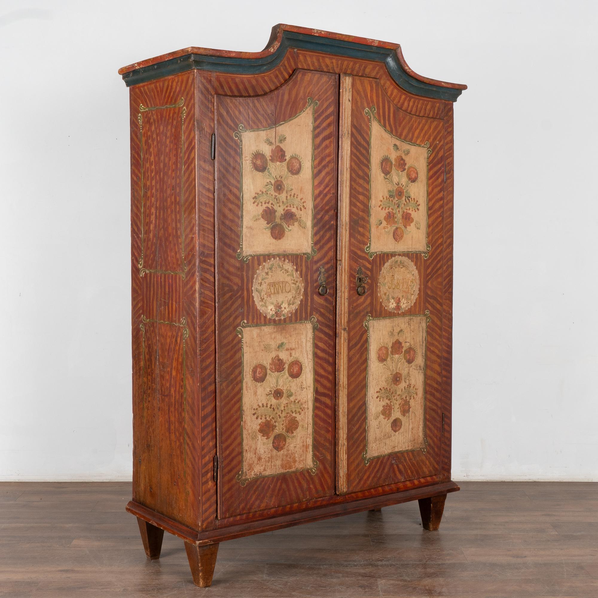 This painted pine armoire still maintains the quality and details of the original hand-painted finish in a soft, inviting earth tone pallet.
The four floral panels are framed against a stylized background that was a traditional style of the era.
The