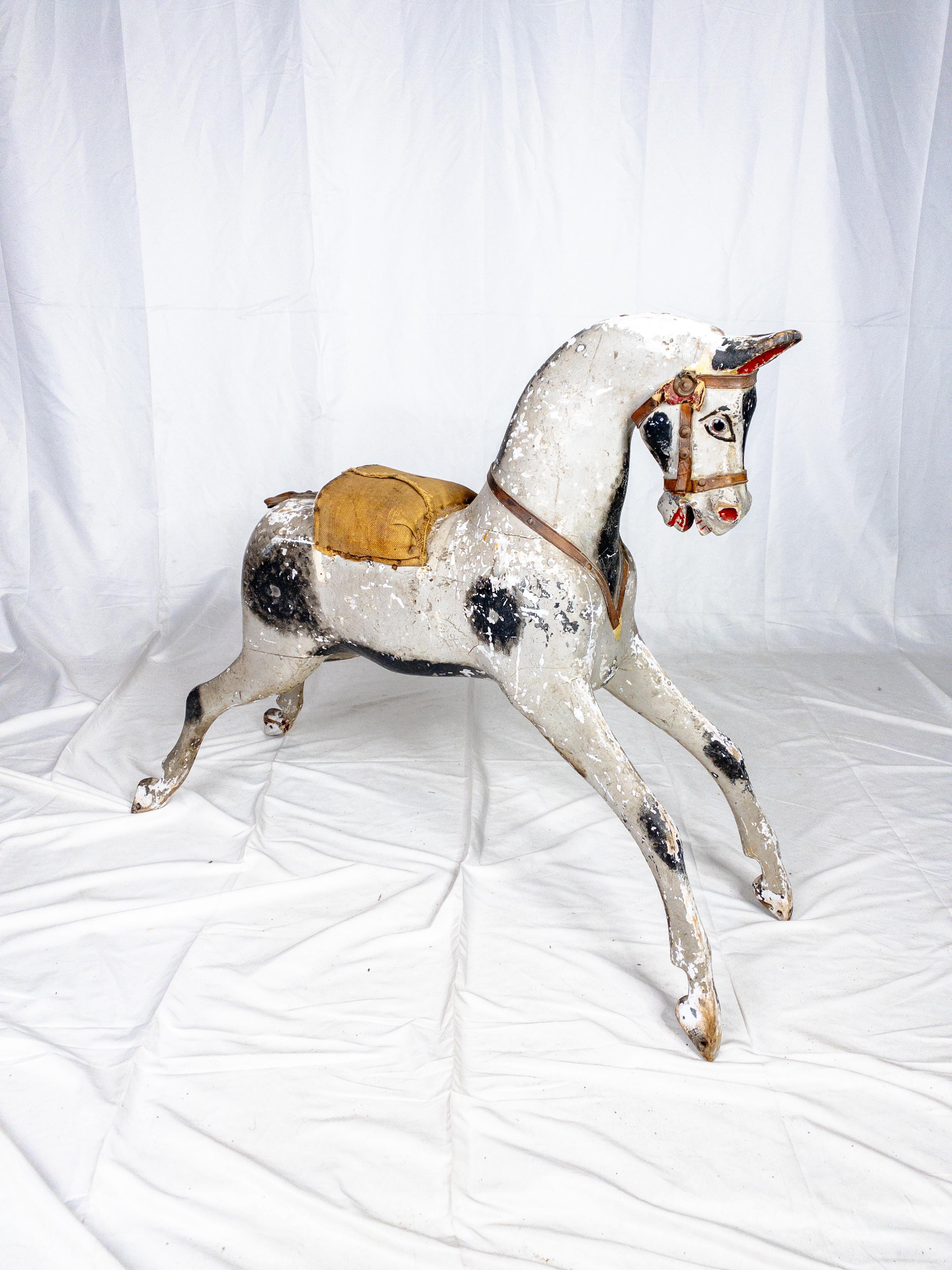 Das Original Paint Rocking Horse aus dem 19. Jahrhundert mit seiner fehlenden Wippe ist ein nostalgisches Relikt, das Geschichten über vergangene Epochen und kindliche Launen erzählt. Trotz ihres Alters hat die charmante Pferdefigur noch Reste ihrer