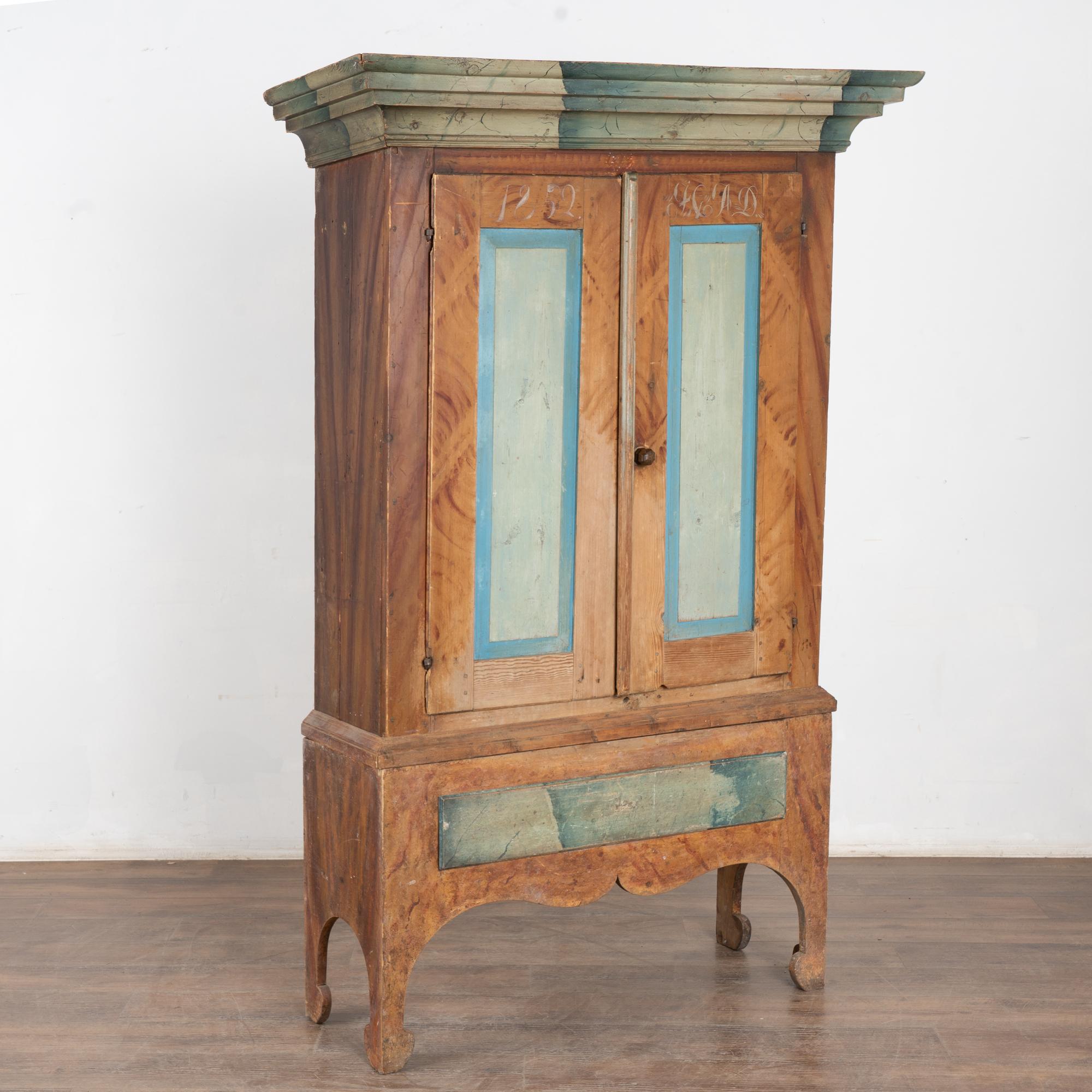 Gli armadi dipinti erano un elemento tradizionale delle case di campagna svedesi; questo è particolarmente bello perché conserva ancora la finitura originale dipinta a mano con cassetti e corona in finto marmo, pannelli dipinti di blu e uno sfondo
