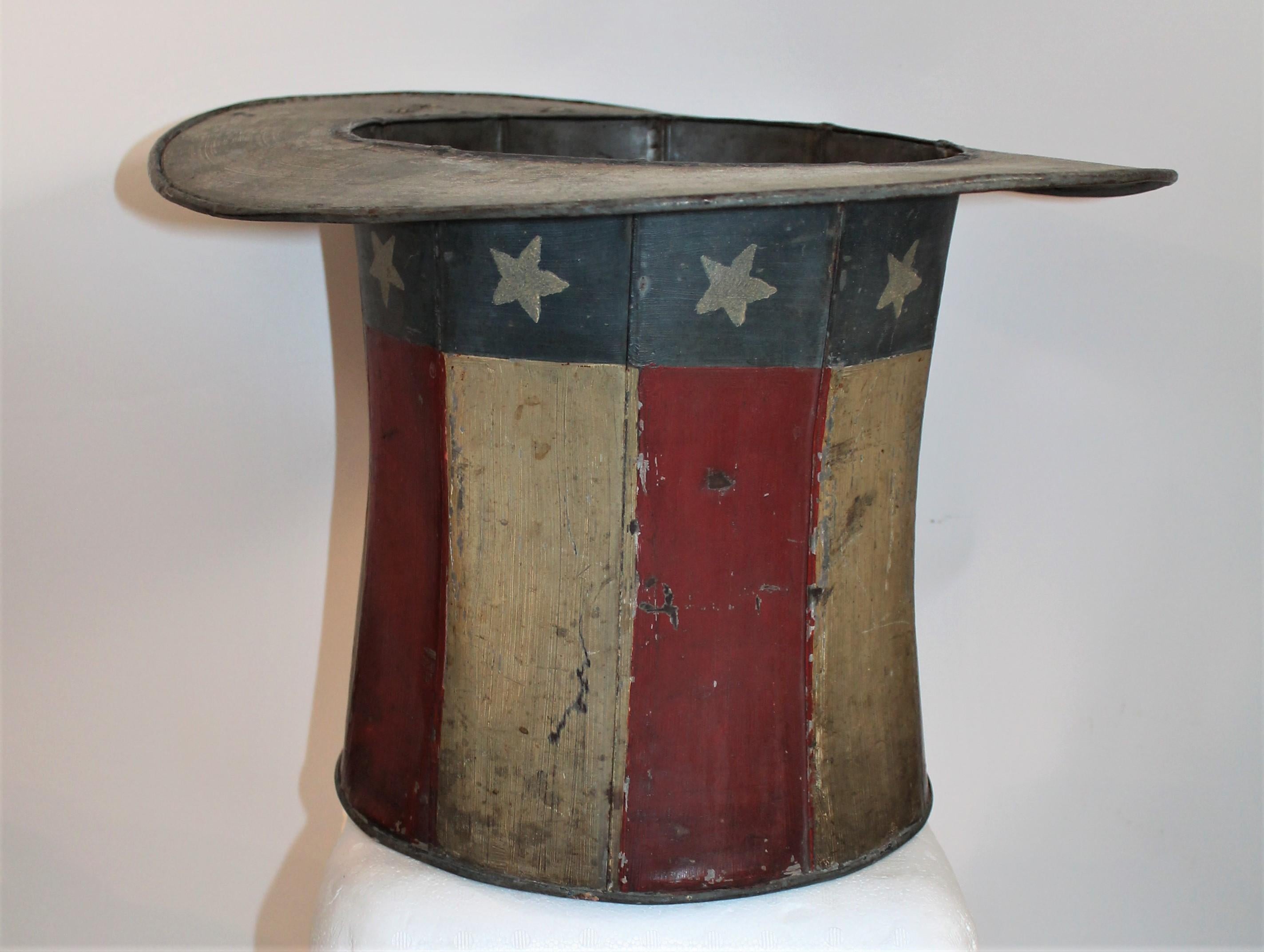 This original painted tin trade sign of a patriotic motif. Looks like a Uncle Sam's top hat. This handmade and painted tin trade sign is signed by the maker and dated 1881.

Interior diameter measures - 10 inches.