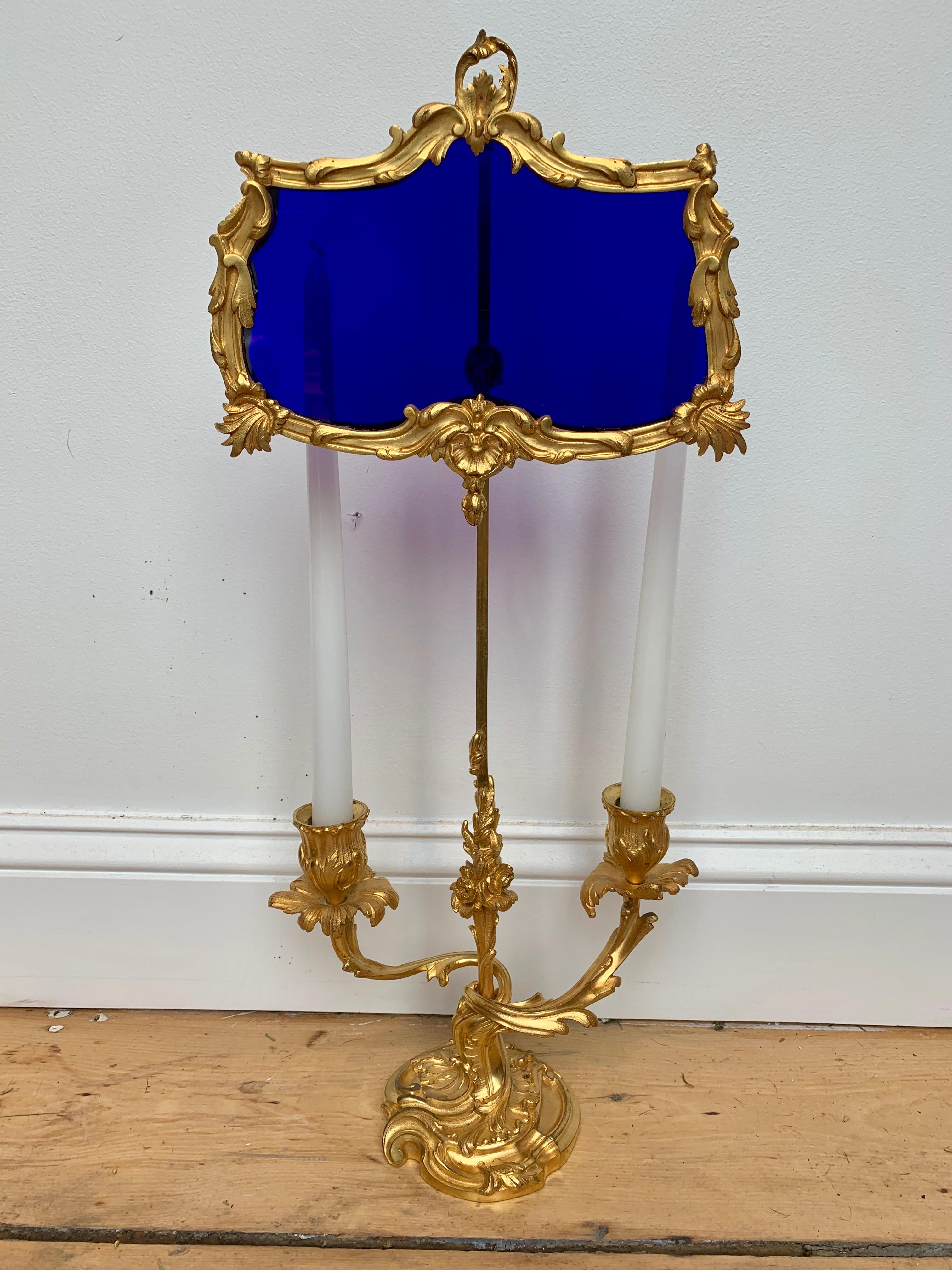 Late 19th century adjustable ormolu and cobalt glass miracle Bouillotte lamp

of fire gilt bronze. Two arms with foliate styling.