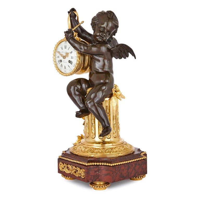 In its unusual and beautiful design, this sumptuous mantel clock effortlessly transcends the boundaries between sculpture, clockmaking and objet de vertu. The piece is modelled as a patinated bronze winged putto dangling the gilt bronze clock case