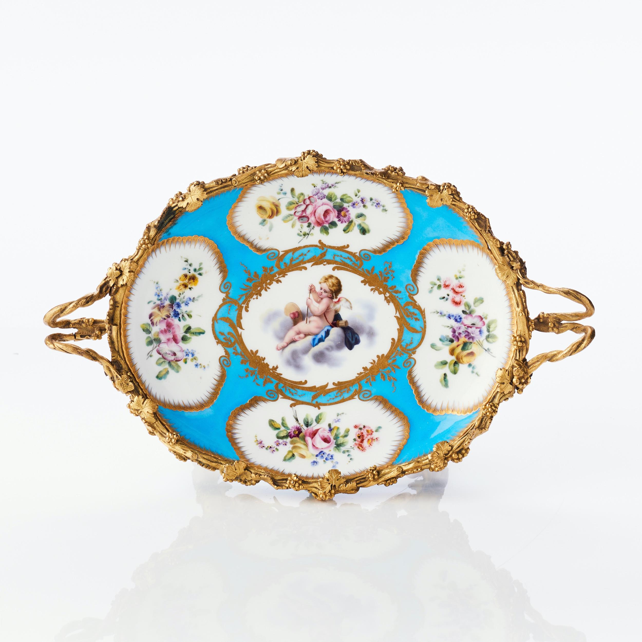 Centrotavola in porcellana di Sèvres blu celeste con ormeggio, probabilmente seconda metà del XIX secolo. Insolita montatura in stile rococò con quattro putti alati che sostengono ogni angolo della ciotola. Alta qualità della fusione e della