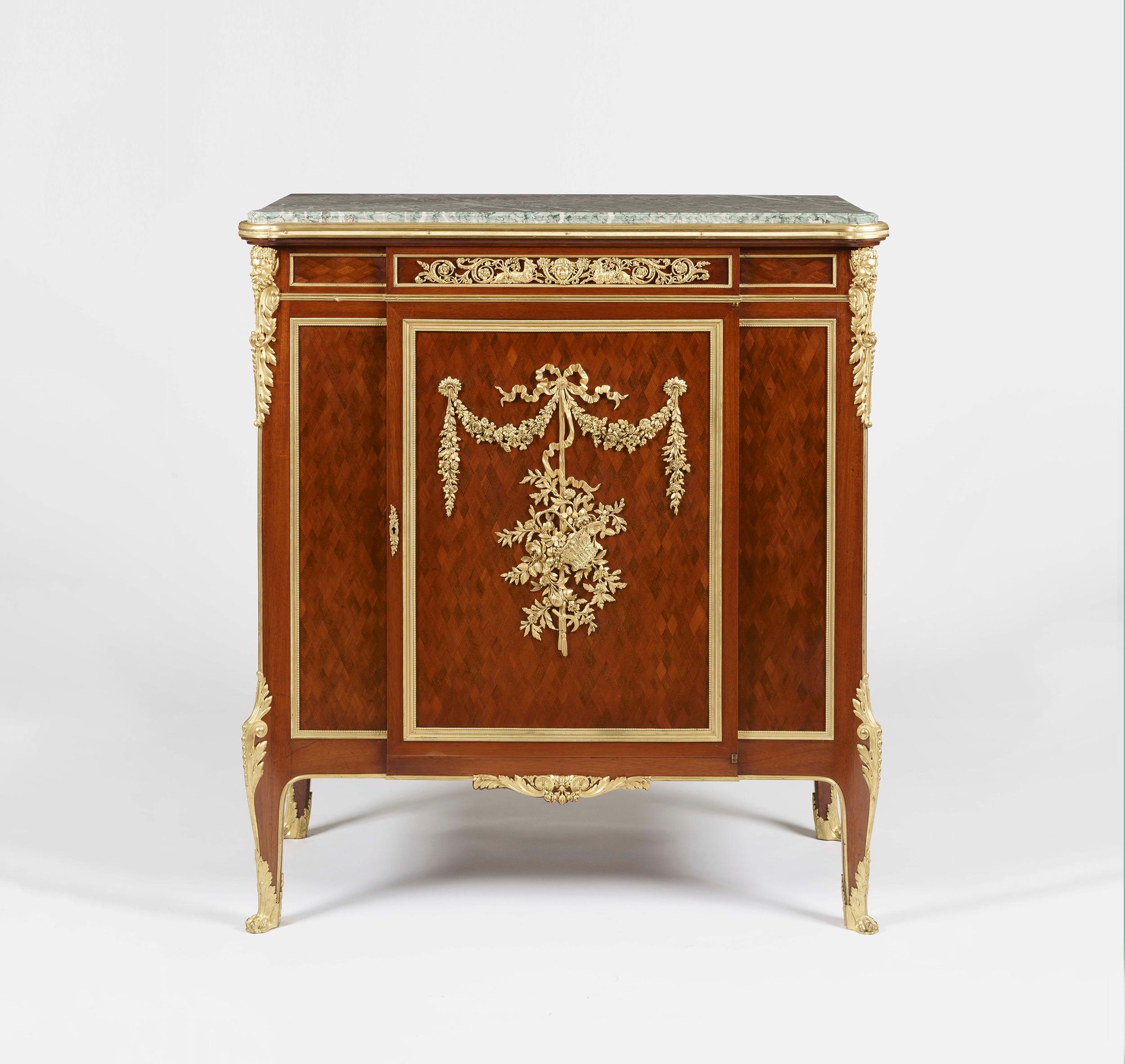 Un meuble à monture ormée et à parquet en acajou
par François Linke

Construit à la manière Louis XV, en acajou parqueterie et orné de montures en bronze doré de la plus belle qualité, avec une plate-forme en marbre Breccia Verde s'élevant de