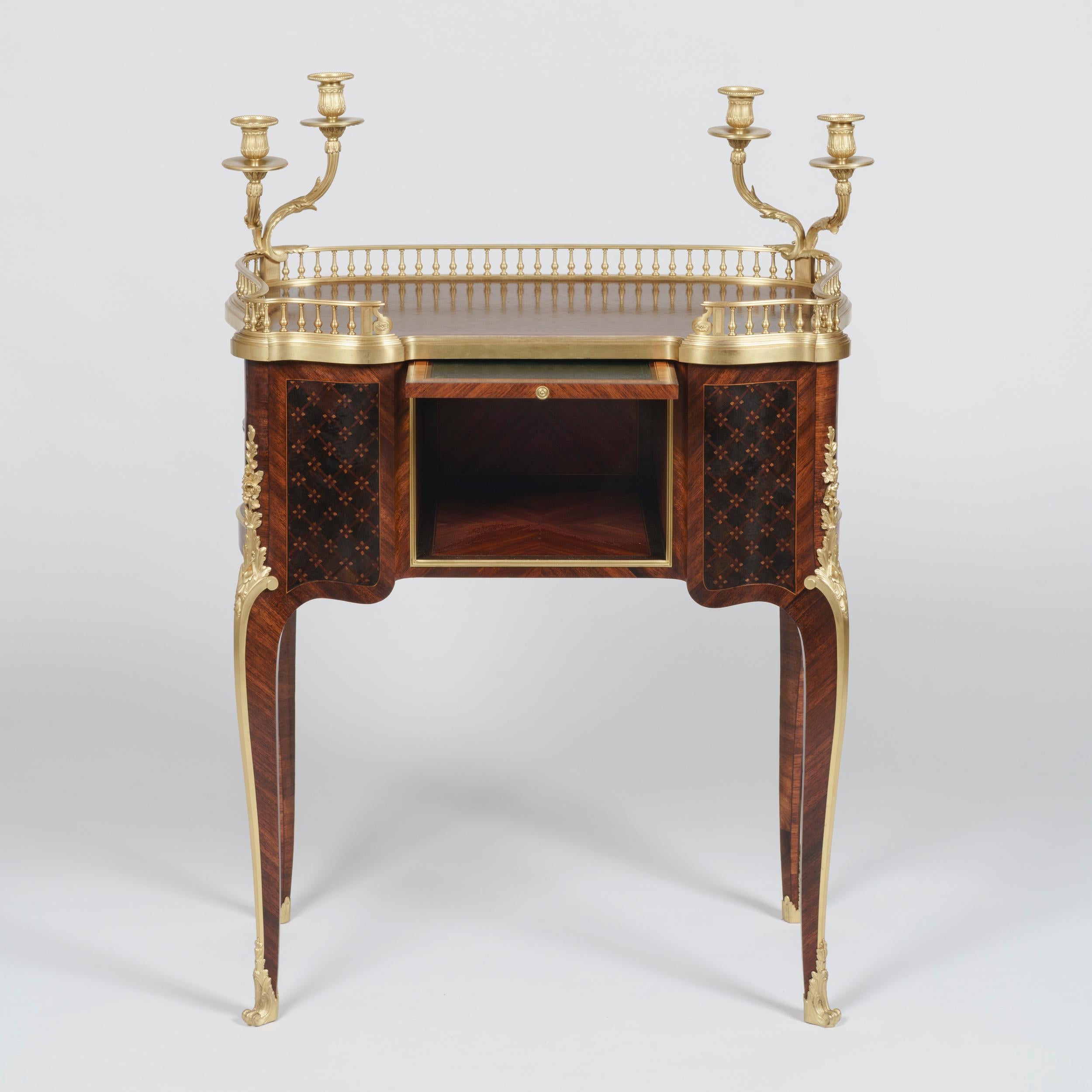 An Elegant Table à Écrire
By Paul Sormani

Constructed from bois satiné and amaranth, with geometric cubed parquetry inlay, the writing table on slender cabriole legs with ormolu floral espagnolettes and scrolled sabots, the inverted breakfront