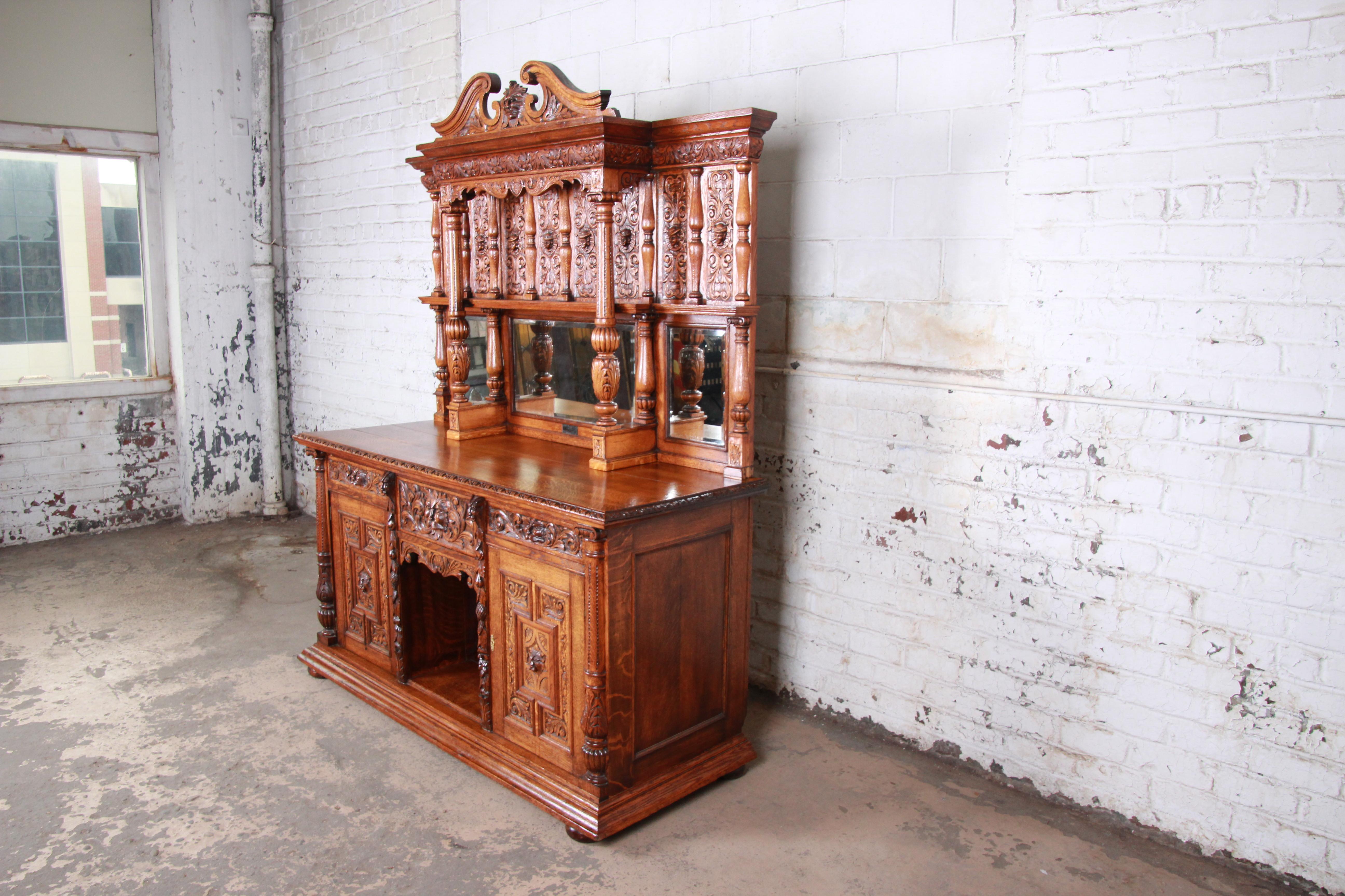 An exceptional antique ornate carved oak sideboard cabinet or back bar

circa 1880s

Oak and mirror

Measures: 72.5