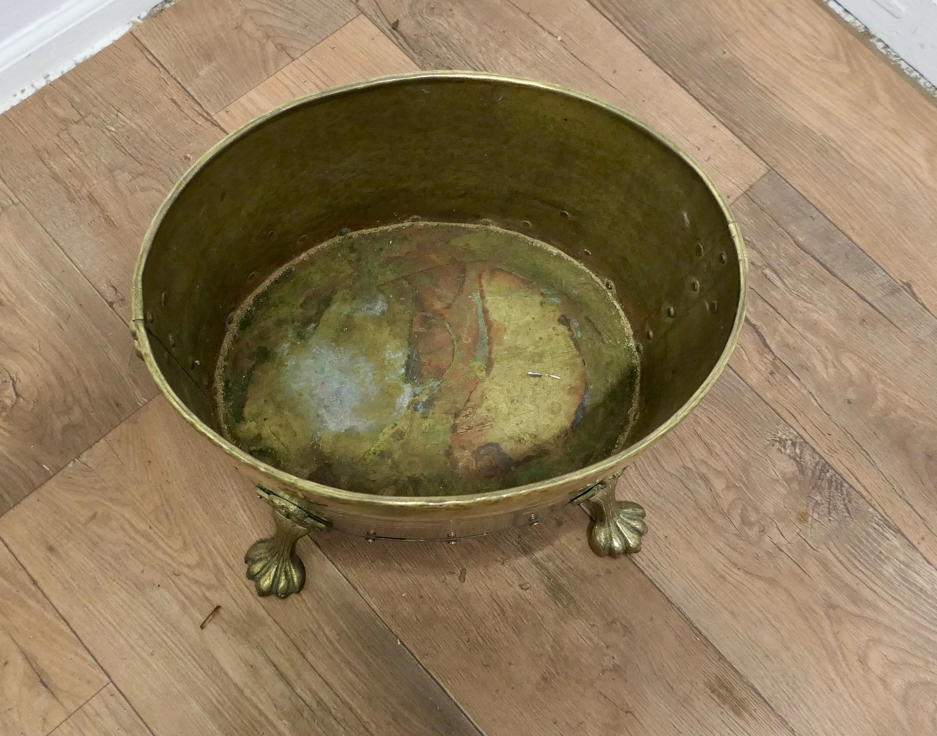 19th Century Oval Brass Lions Mask Log Bin  

This is a superior quality Brass log or coal bin, it has a heavily riveted construction at the seams, 2 Lions Mask handles and it is set on 4 chunky lions paw feet.
The Brass Cauldron would work well as
