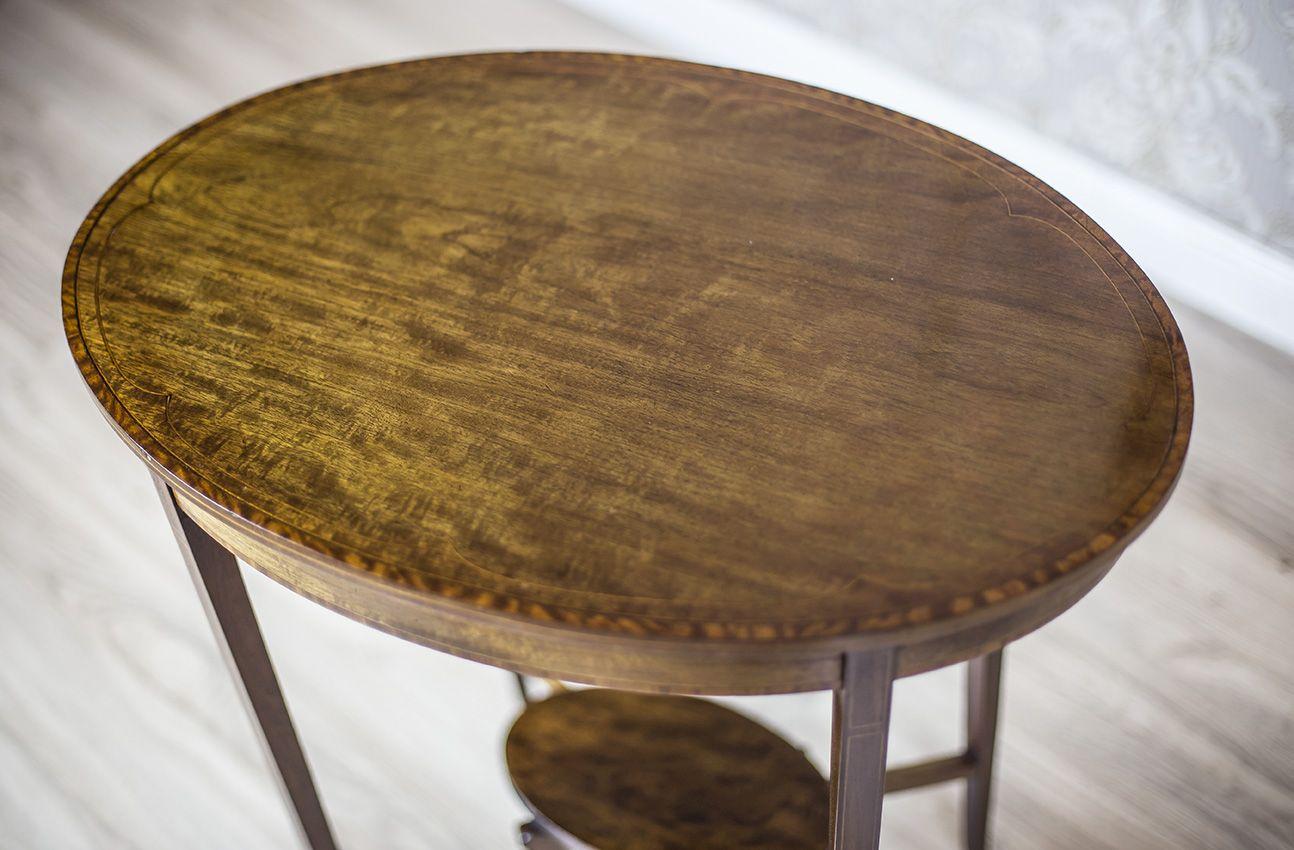 We present you a neat, wooden side table of a lightweight design.
The whole is from the 2nd half of the 19th century.
The oval top is supported on thin legs, which are connected with stretchers with an oval shelf.
Furthermore, the legs, top and
