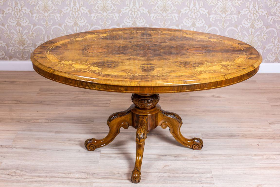 We present you this table from the Victorian era made of walnut, with a top covered with burl veneer.
The oval tabletop is supported on a turned pedestal, which turns into a quadripod that ends with volute feet.
Furthermore, the surface of the top