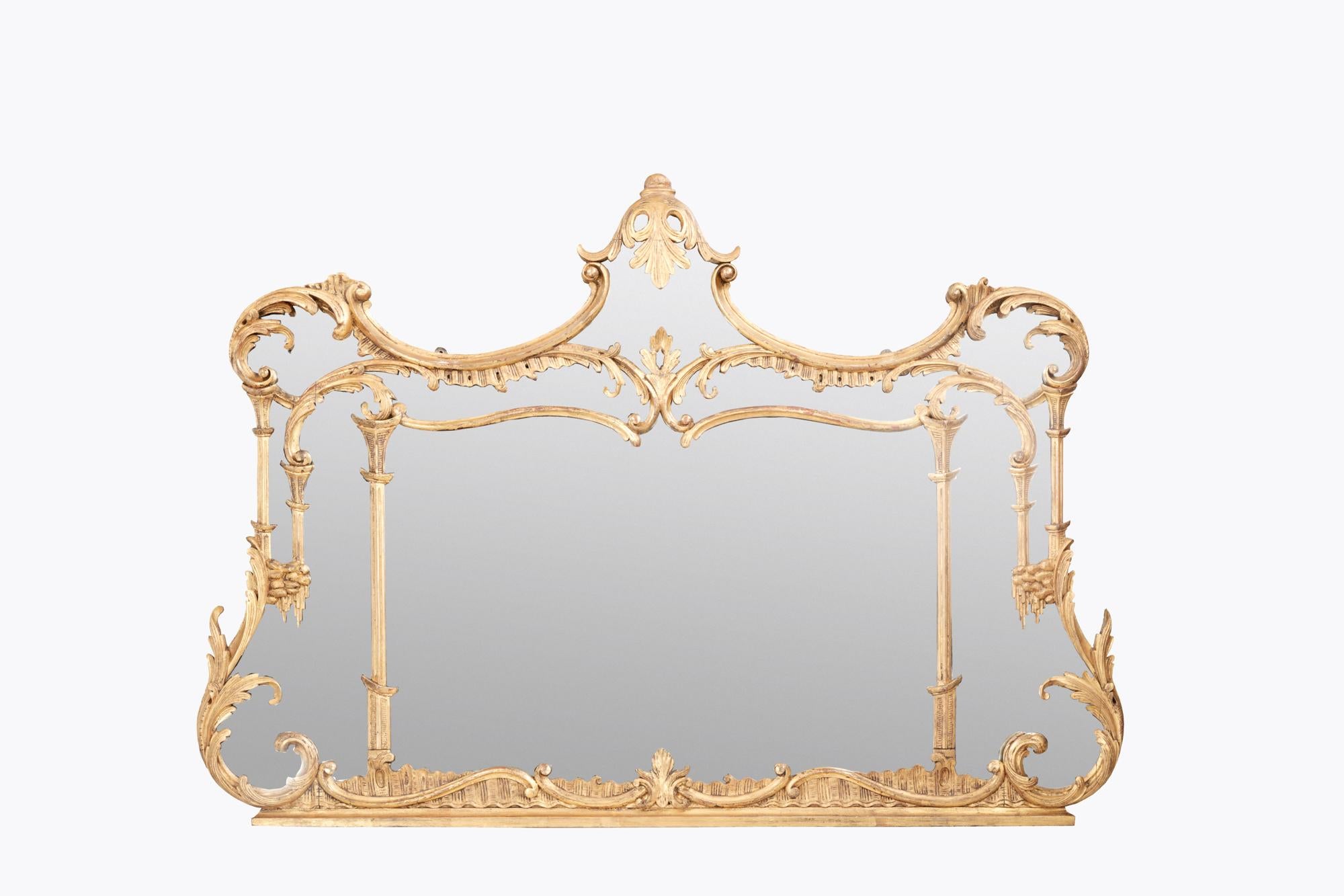 19th Century overmantel mirror with sweeping acanthus leaf and scroll detailing throughout. The gilt frame is embellished with subtle Chinese Chippendale style features, including pagoda pillars. Stylised waterfall detailing adorns the inner