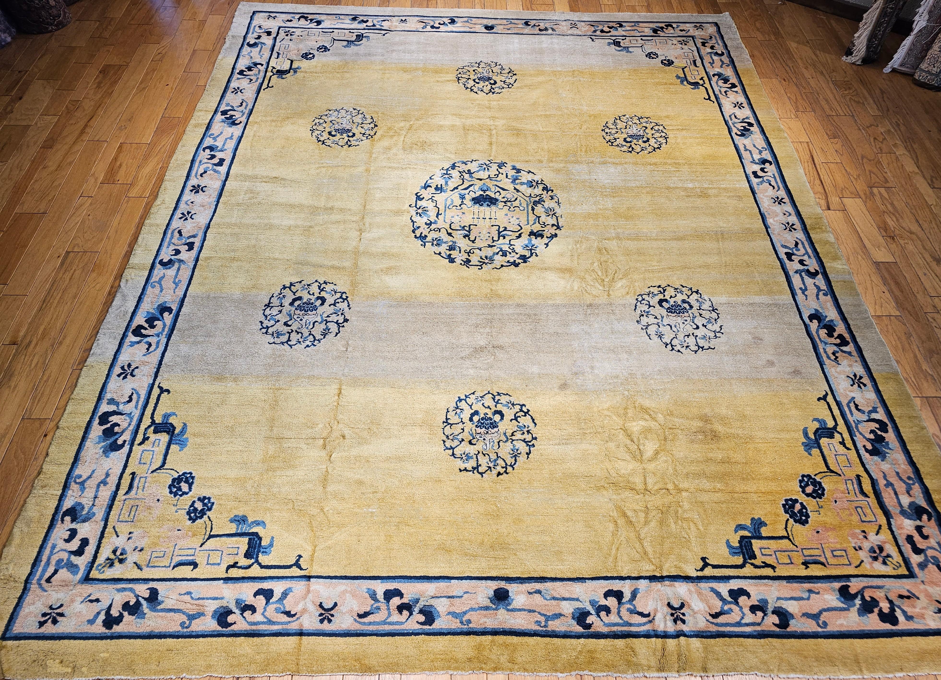 A beautiful Chinese Peking oversized rug from the late 1800s.  The rug has a very unique and beautiful pale yellow color with an open design.  The design in the field consists of a large medallion with lion dogs surrounded by cloud wreaths.  The rug