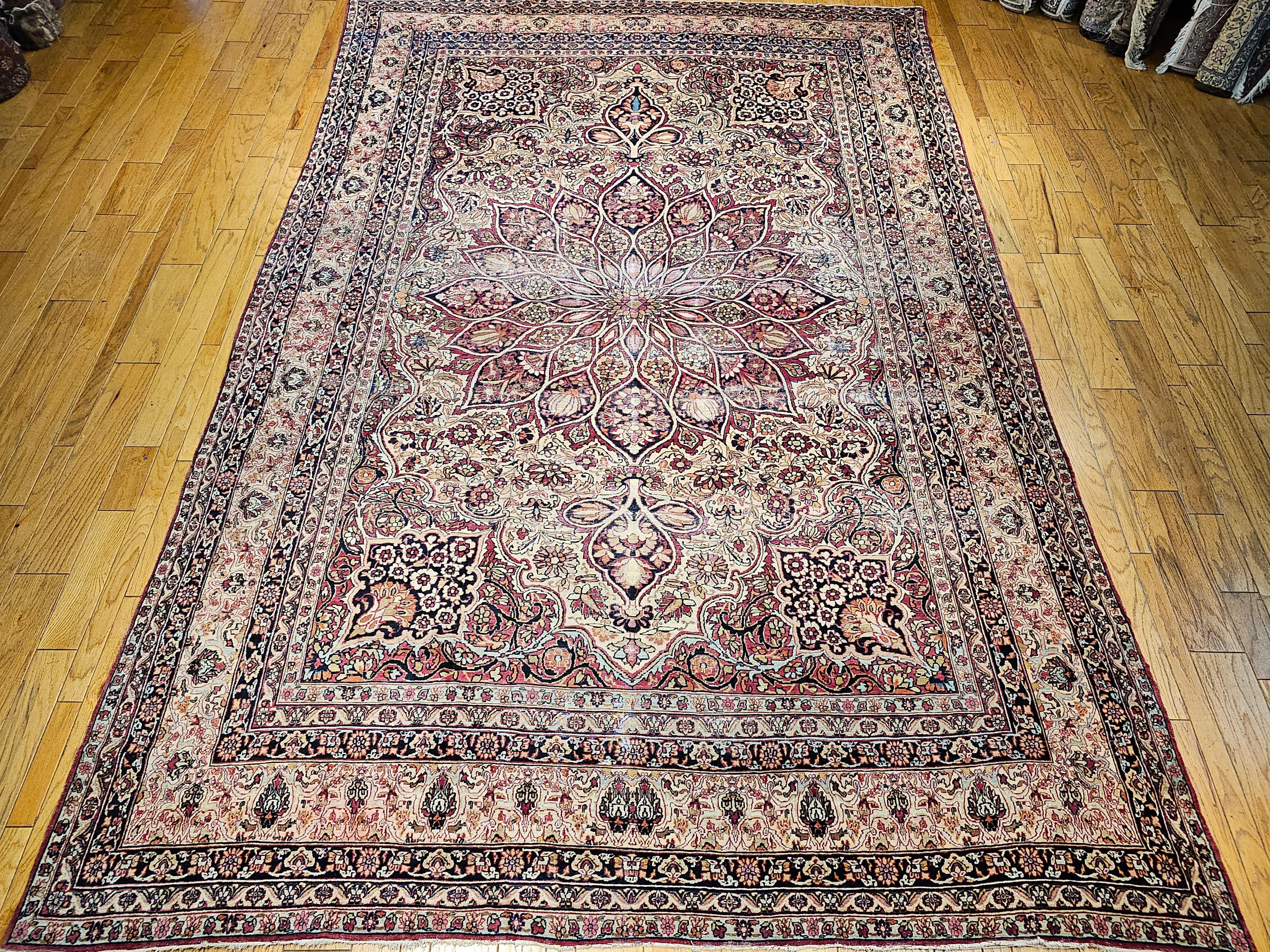 A beautiful oversized Persian Kerman Lavar from the 4th quarter of the 1800s.  The Kerman Lavar rug has a central medallion in a very detailed and intricate manner.  The primary color in the field is antique cream with accents of red, turquoise,