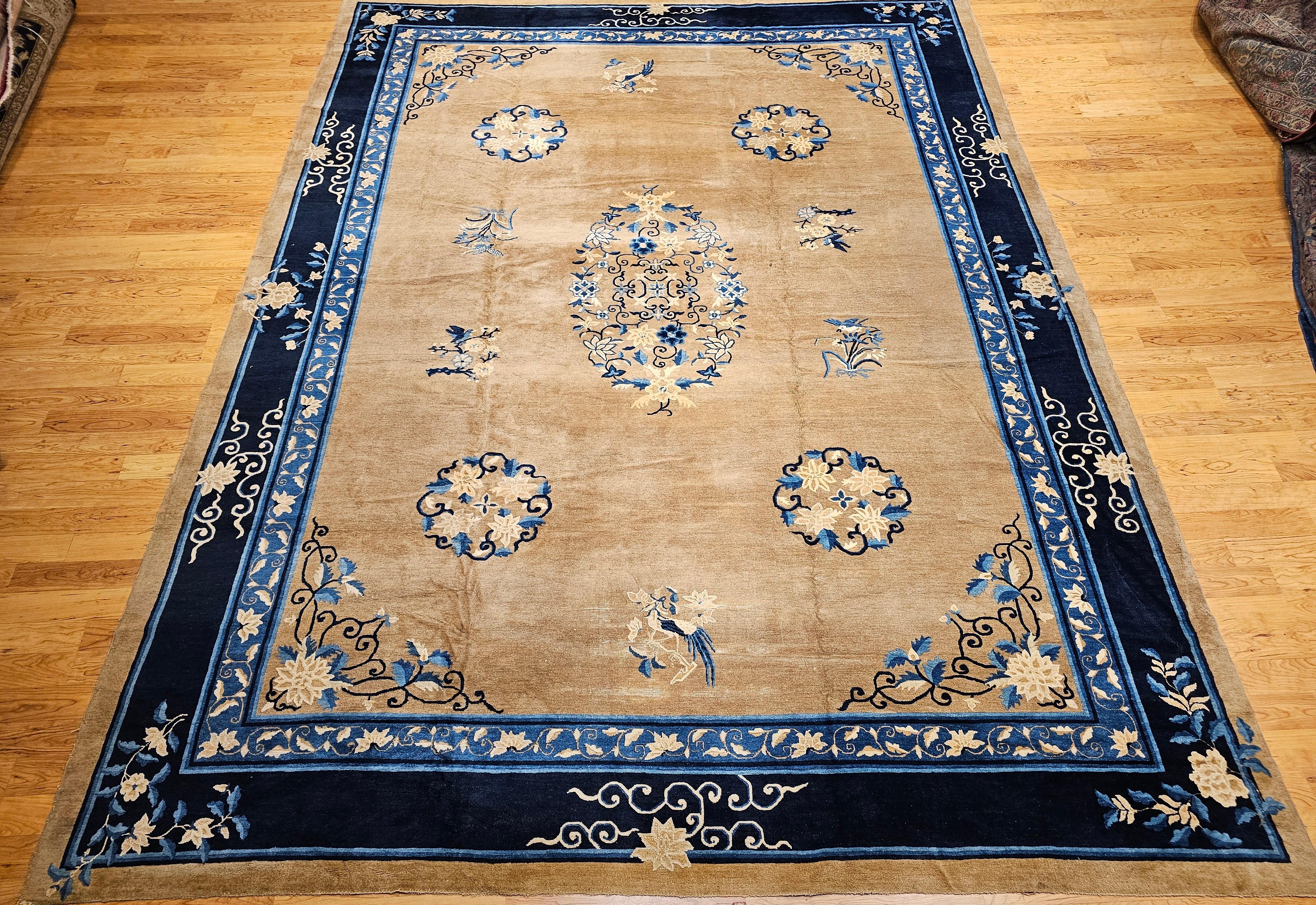 This 19th century oversized Chinese Peking rug is a timeless masterpiece, showcasing the refined artistry of traditional Chinese weaving. Featuring a soft tan field, the rug is beautifully framed by a navy blue primary border and a French blue