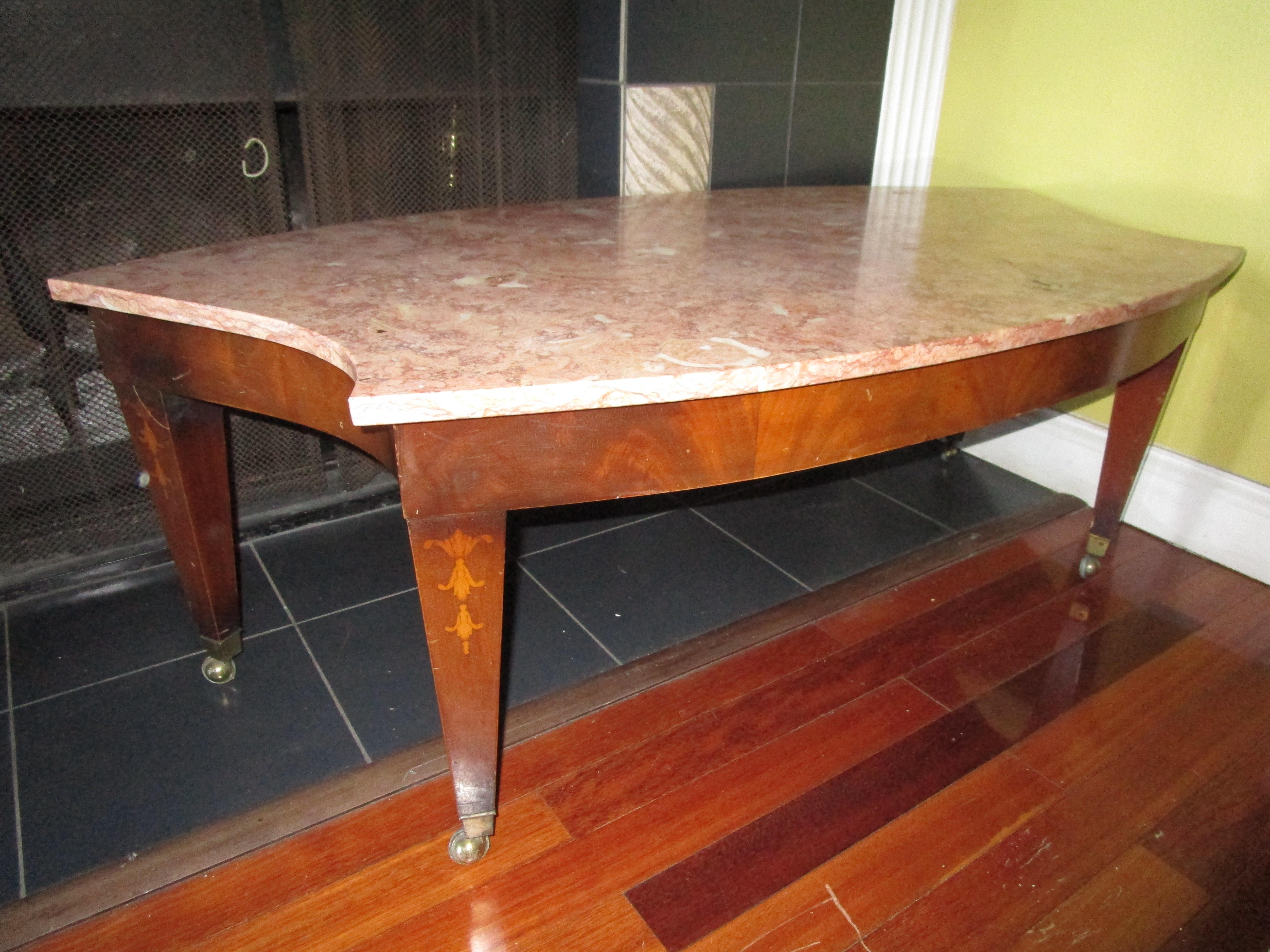 The novel shape and color of this Breccia marble coffee table will turn heads and transform a living or work space. This vintage Federal ovoid marble-top and inlaid mahogany or cherrywood coffee table will create a splash of color and excitement. It