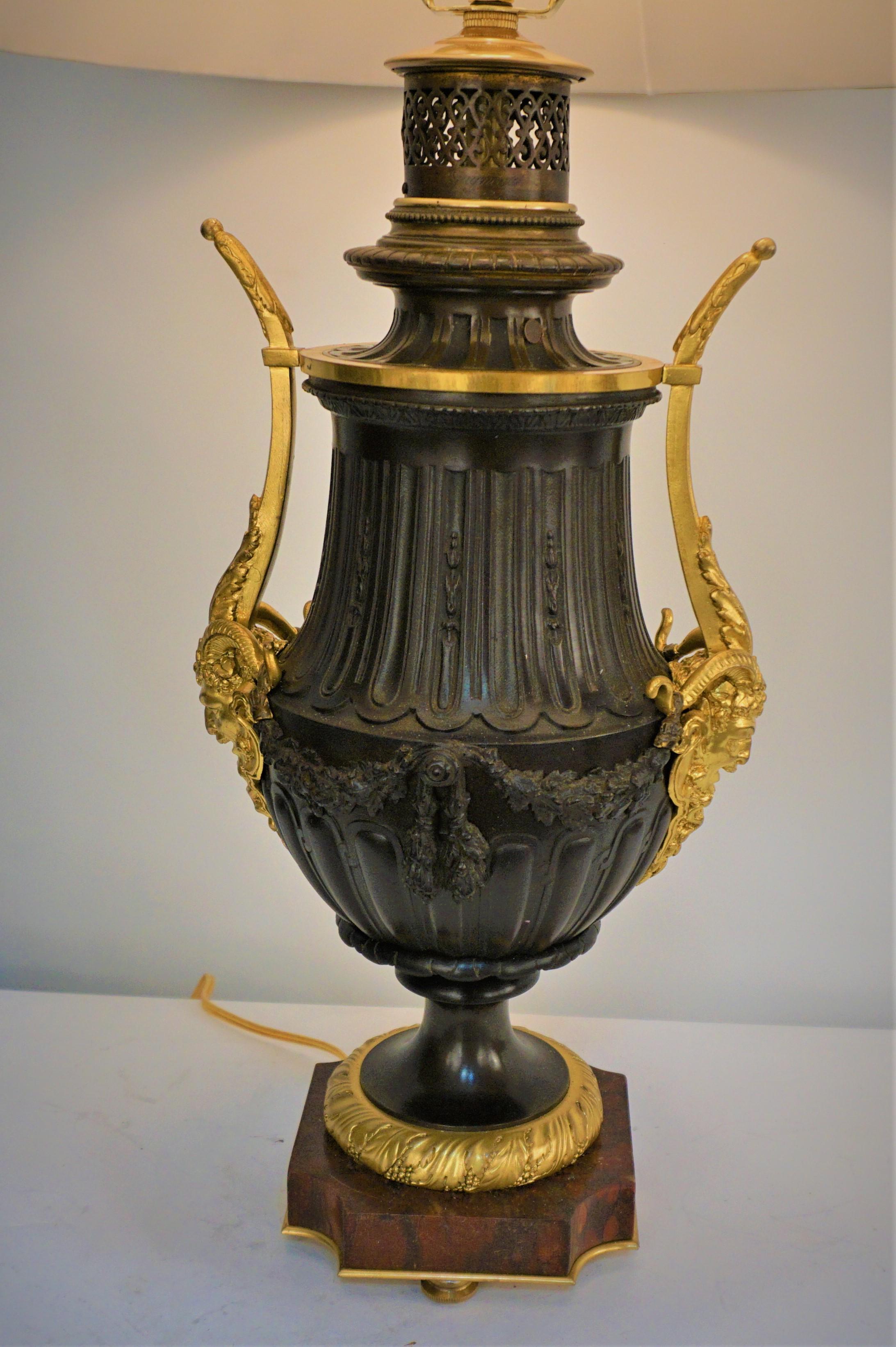 Lampe à huile du 19ème siècle, de couleur brun foncé, en bronze glit, électrifiée par un professionnel et équipée d'un abat-jour en soie plissé.
Prise 3 voies, jusqu'à 250watts.