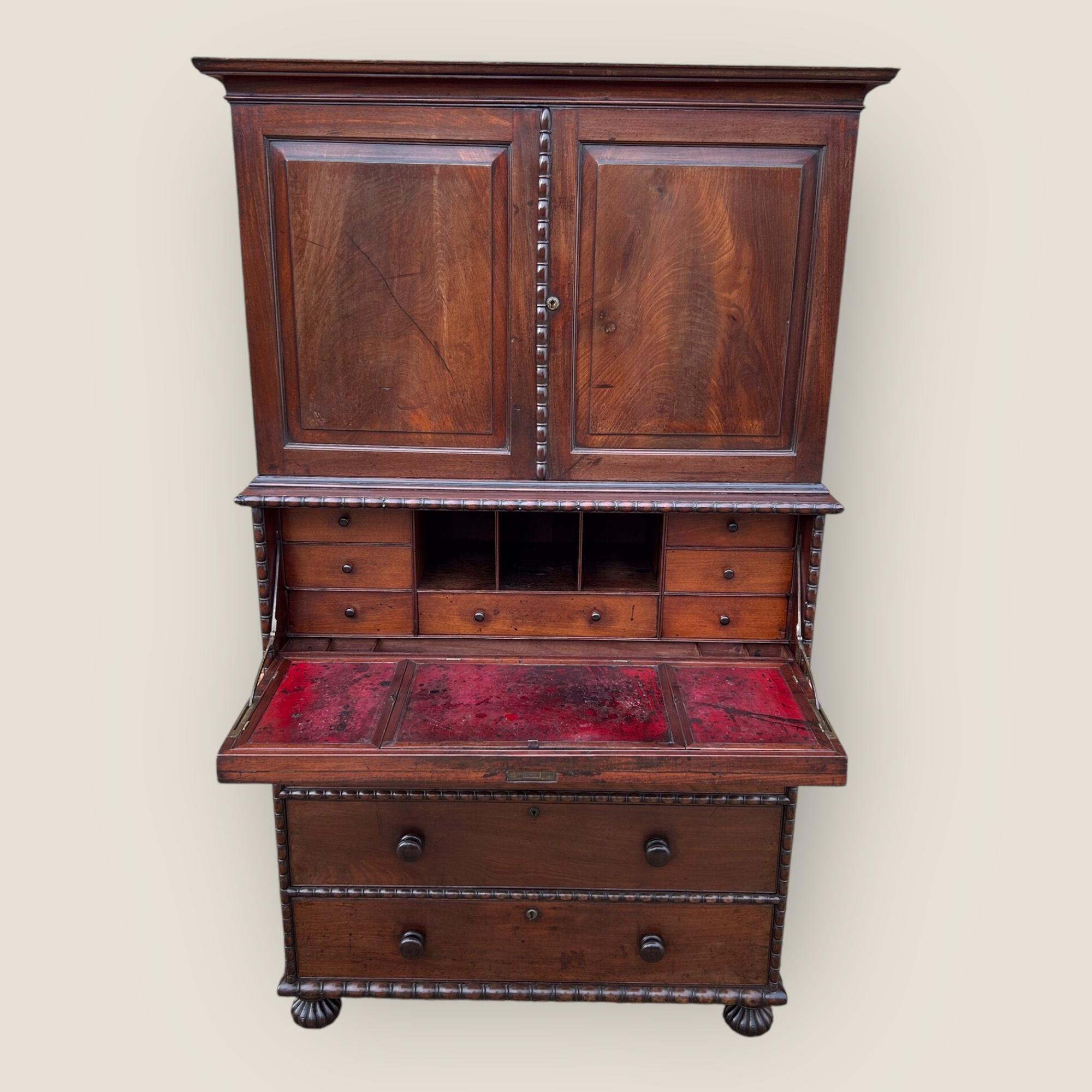 Una cassapanca da campagna anglo-indiana Padouk dell'inizio del XIX secolo con un secretaire e un armadietto. Con modanature intagliate a canapiglia su tutti i bordi, piedi torniti a canapiglia e maniglie rotonde in legno. Il cassetto superiore più