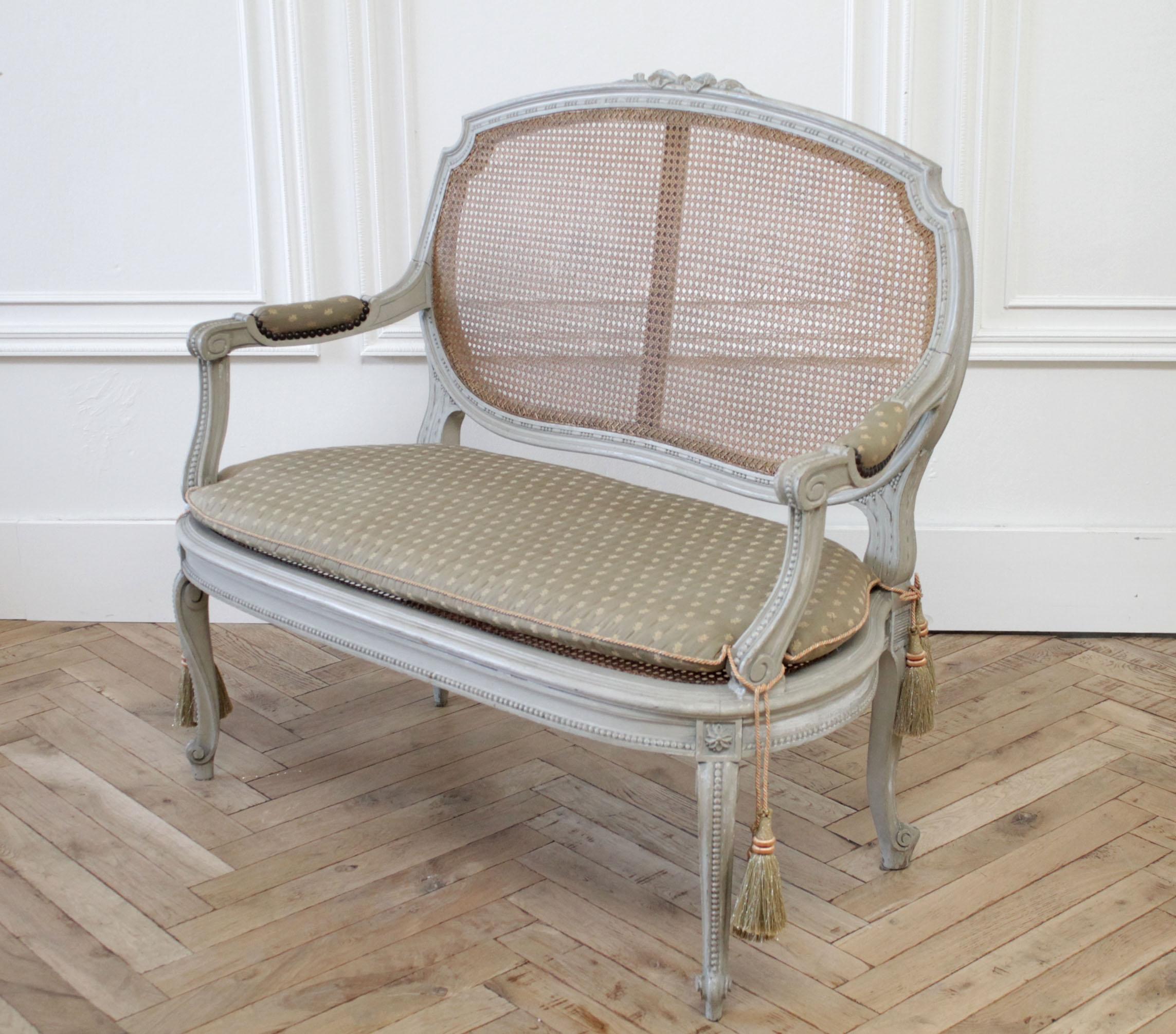 19th century painted and carved ribbon cane settee
Painted in a soft pale Swedish gray color, with natural cane back and seat. No flaws to the cane back, and seat. The seat looks to have been redone, as the color is a little more lighter brown