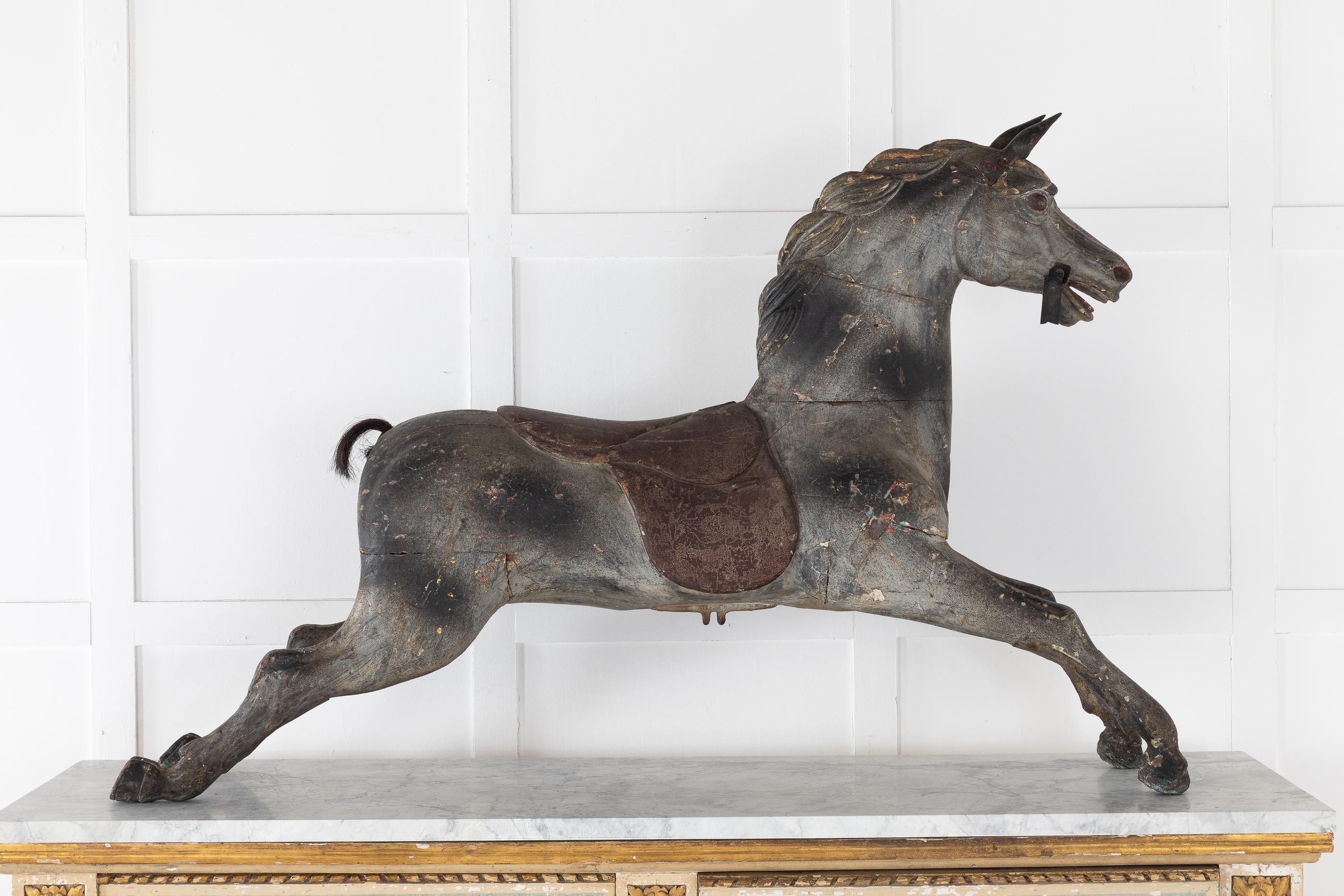 An amazing decorative statement; this 19th century, charming painted carved wooden carousel horse shows character. With metal ears and old paint, the original paint is underneath, but we chose to leave its old paint. Very nicely carved enchanting