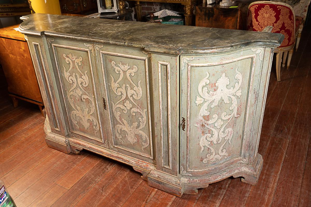 Beautifully shaped and paint decorated enfilade/buffet. The depth of the piece allows it to be used in various rooms in various ways. The color is a beautiful light griege that will blend with any color pallet throughout the home. It is perfect for