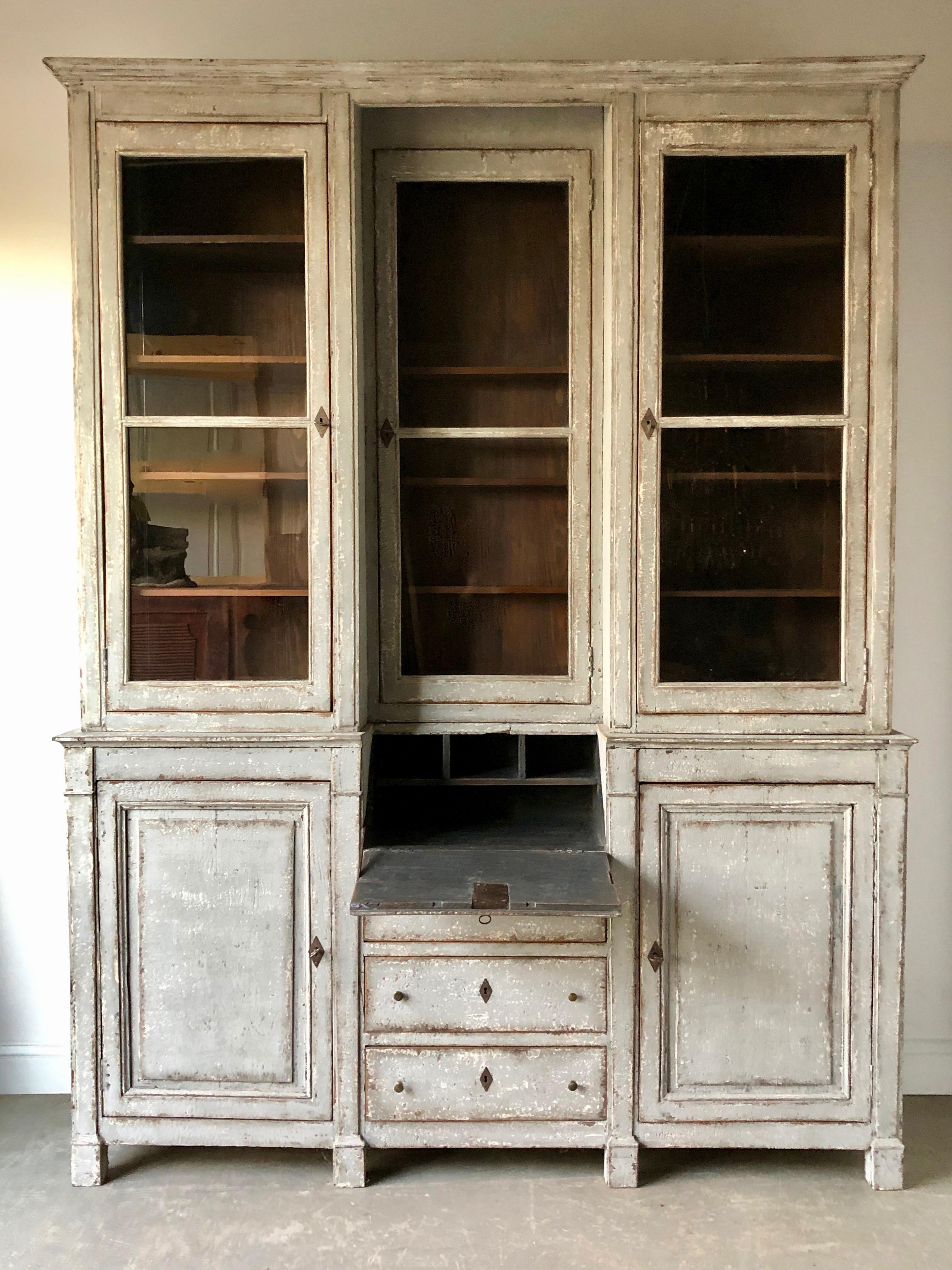 A very large 19th century painted Bibliothèque with writing surface from France. The glazed top panels have their original glasses and the bases are with fielded panel doors and three drawer secrétaire between. Lot of storage. 
addition 12.75