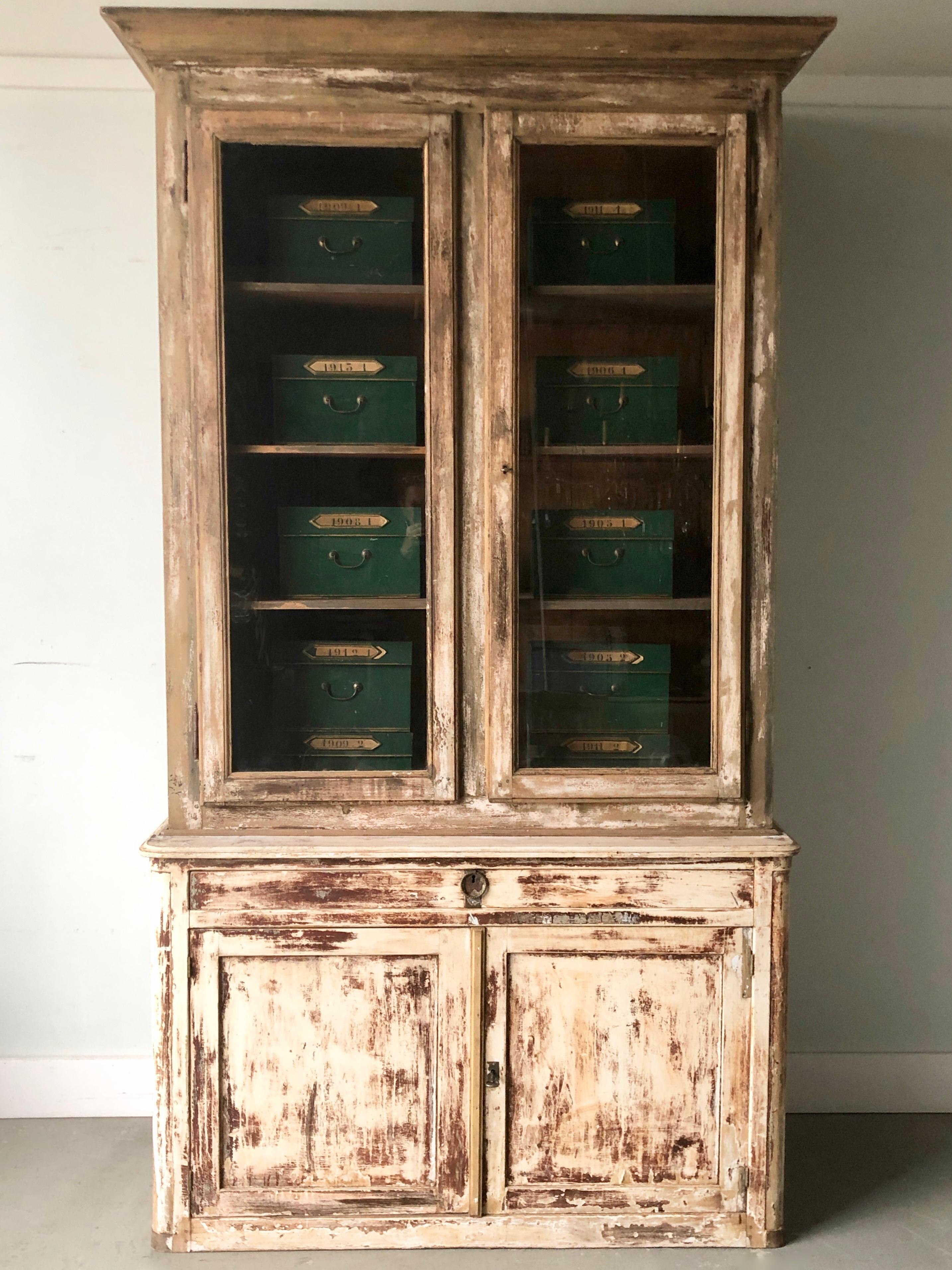 19th century painted French Bibliothèque in two parts with all original; worn paint and hardwares. France, circa 1880. Measurement are with cornice and baseboards.
Upper cabinet with three stationary shelves.
Large drawer under and lower cabinet