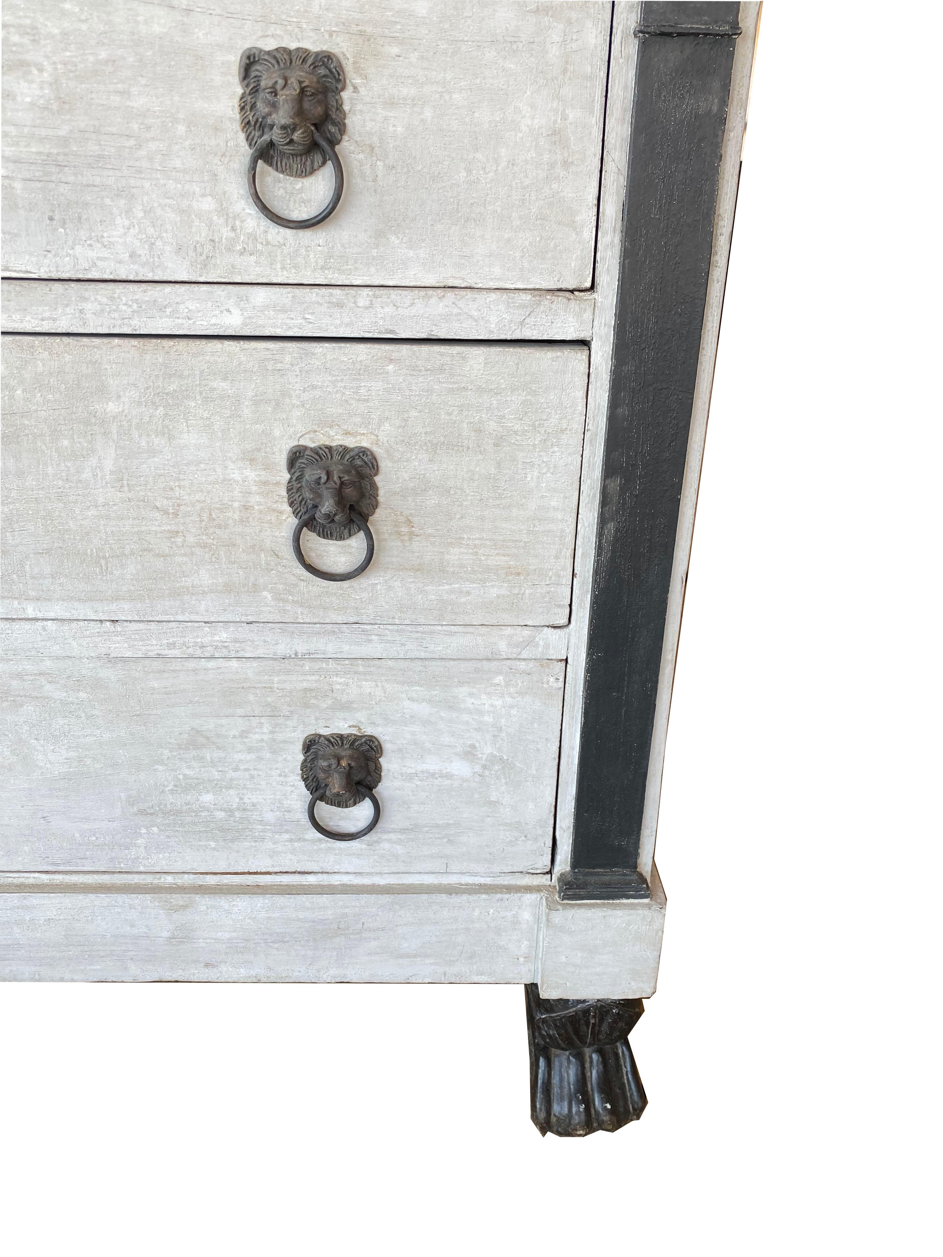 Period antique French Empire painted chest of drawers with beautiful black marble top. Beautiful decorative lion brass hardware and working key. Early and all original. Footed legs in front. Could mix well with Swedish and Gustavian pieces as well.