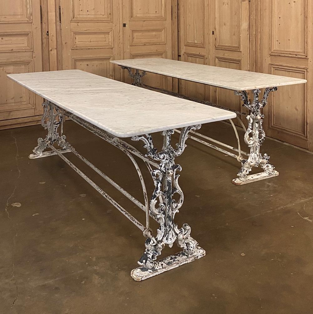 19th century painted iron sofa table, counter with Carrara marble is a stunning piece with abundant detail in the intricate wrought and cast iron base below. Elegant scrollwork with fleurs de lys, a Norseman's visage, and stylized acanthus plumes