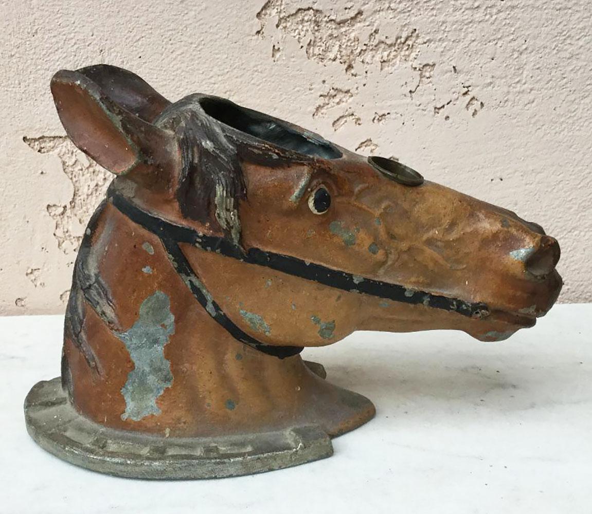 Tête de cheval en métal peint sur fer à cheval, vers 1890.
 