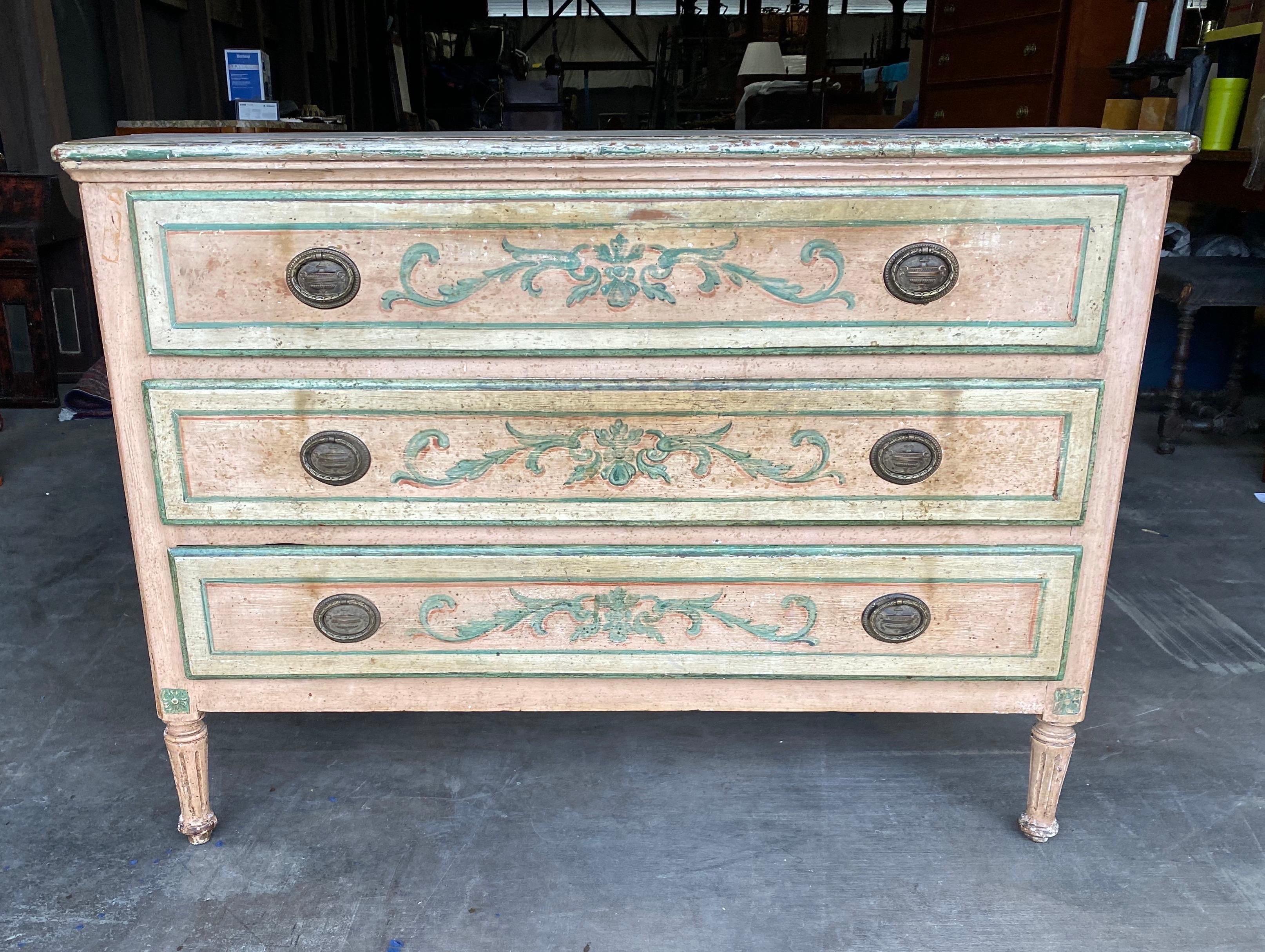 19th century painted polychrome Venetian 3 drawer commode with shaped sides. Lovely pale pink and white paint with green outlined and floral painted drawers and sides.