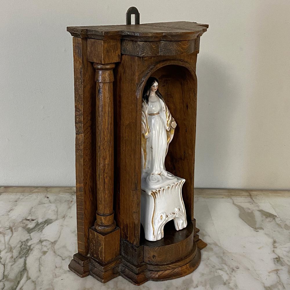 19th century painted porcelain Madonna in original handcrafted oak shrine is the perfect choice for your private devotional area. Designed to mount on the wall or to sit on a surface, the hand-sculpted shrine features multi-tiered molded detail with
