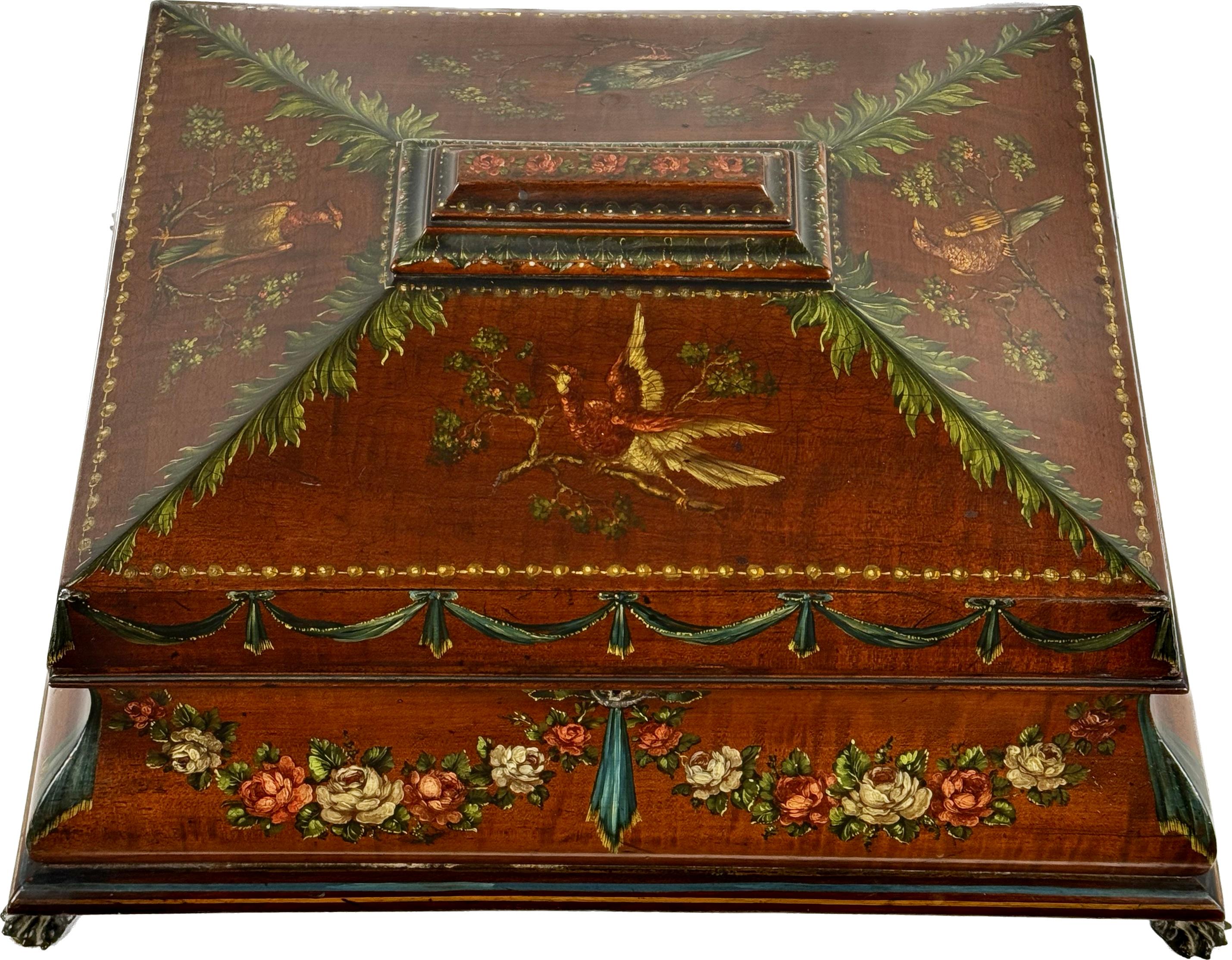 Unique satinwood painted English dresser box from the 19th century. Box has colorful floral and ribbon design with exotic birds on a beautiful satinwood background. Designs are in earth tone colors of green, cream, pink and teal with gold trim.