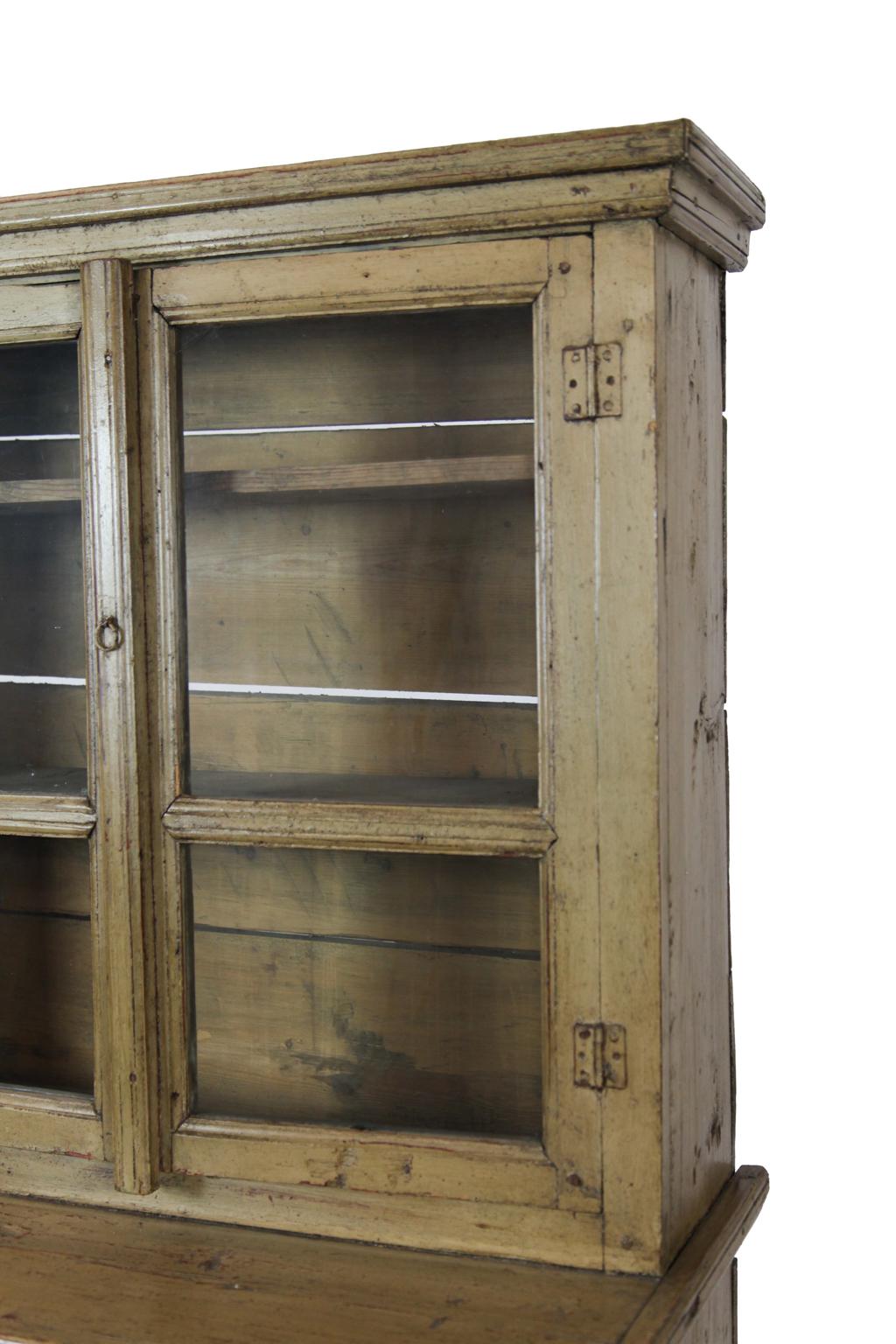 19th century painted step back cupboard, with double glass doors above 9 inch deep platform, single long drawer above double raised panel doors, on simple bracket feet.